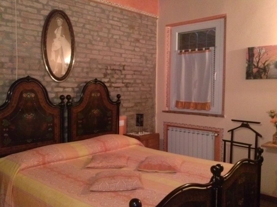 Room with brick wall and a double bed