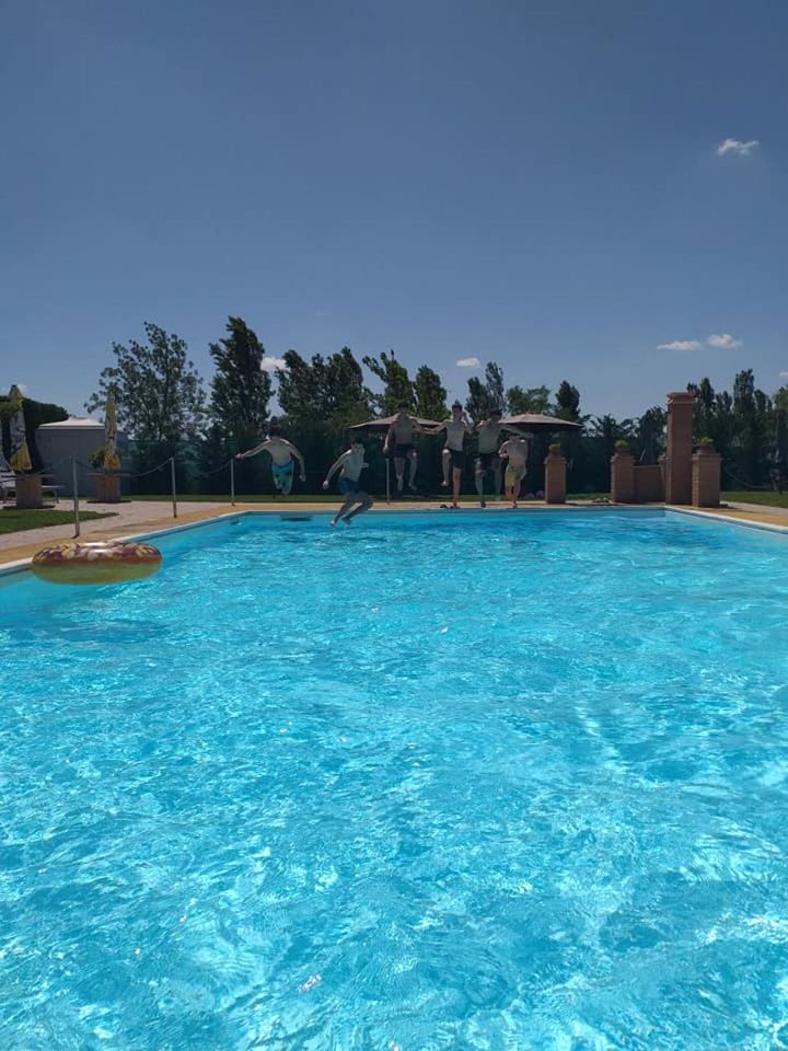 Piscina di giorno con bambini che si tuffano