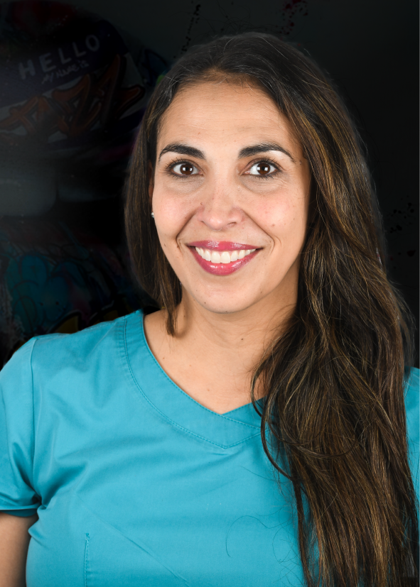 Una mujer con cabello largo y castaño, vestida con una blusa verde azulado, sonríe.