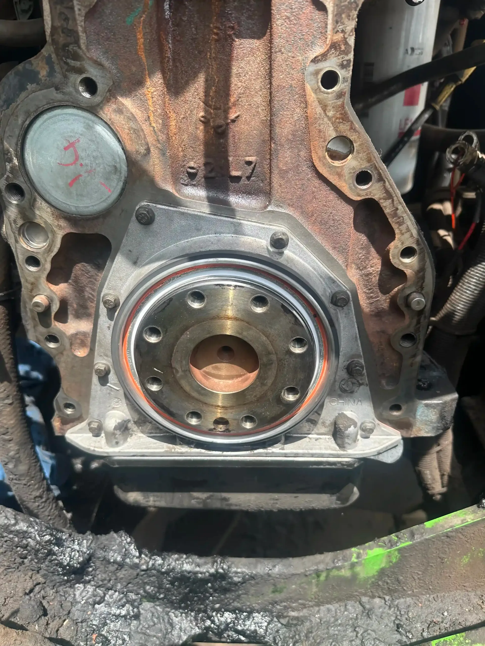 A close up of a rusty engine block with a bearing on it.