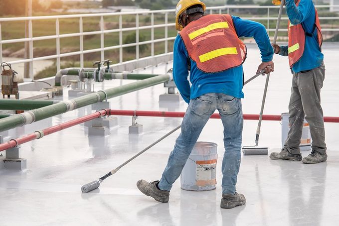 Workers Waterproofing The Roof