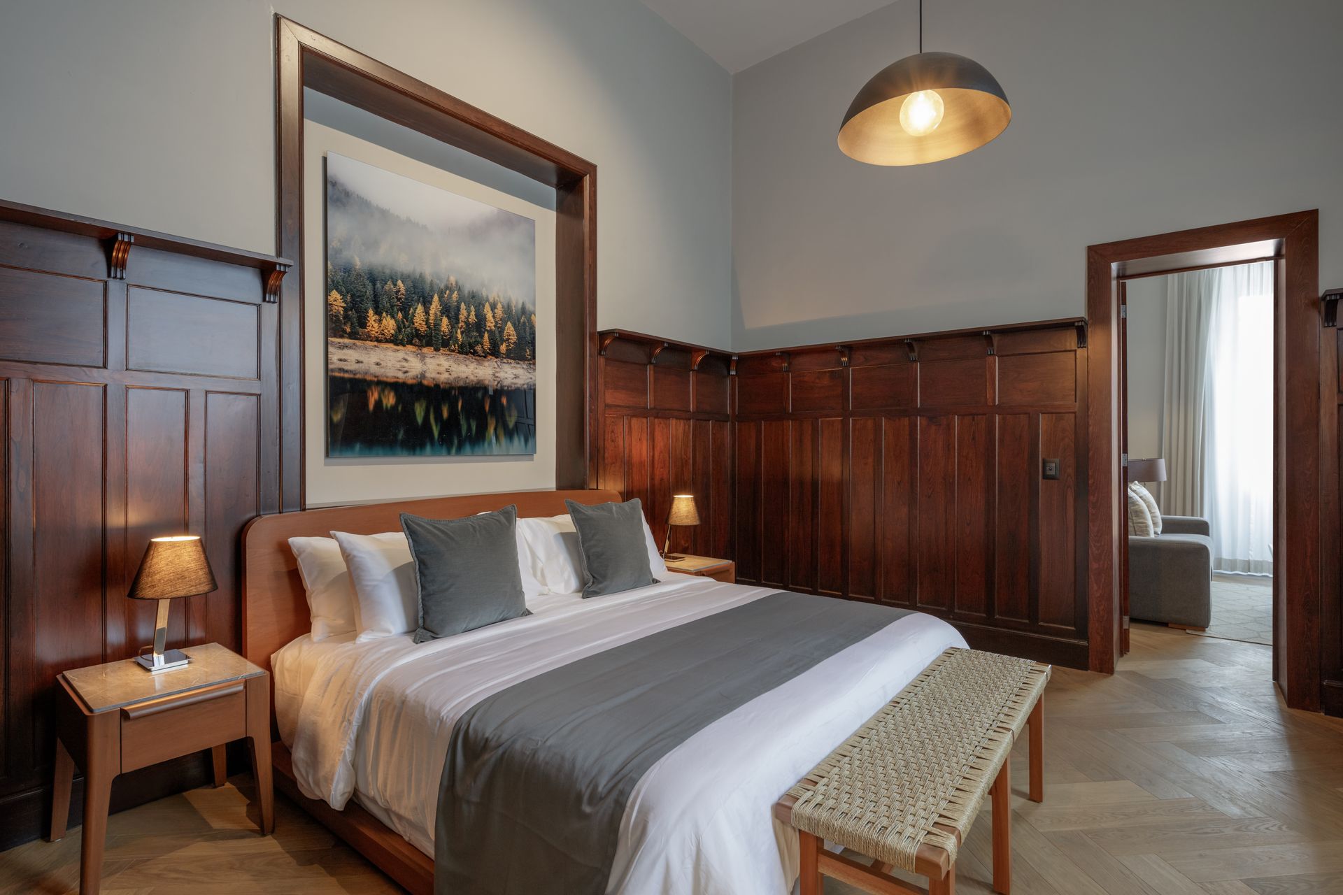 A bedroom with a large bed and a painting on the wall.