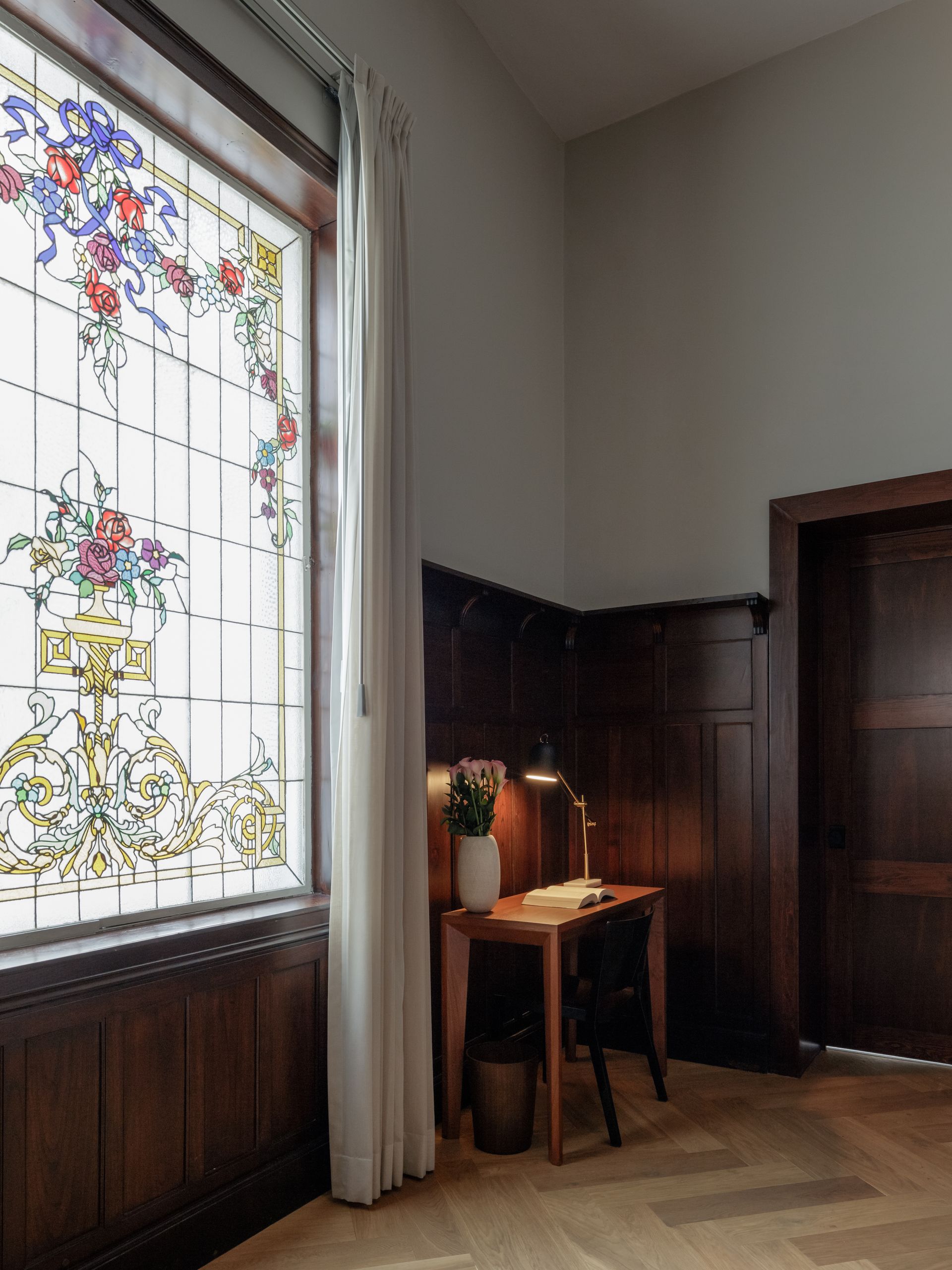 A room with a desk and a stained glass window