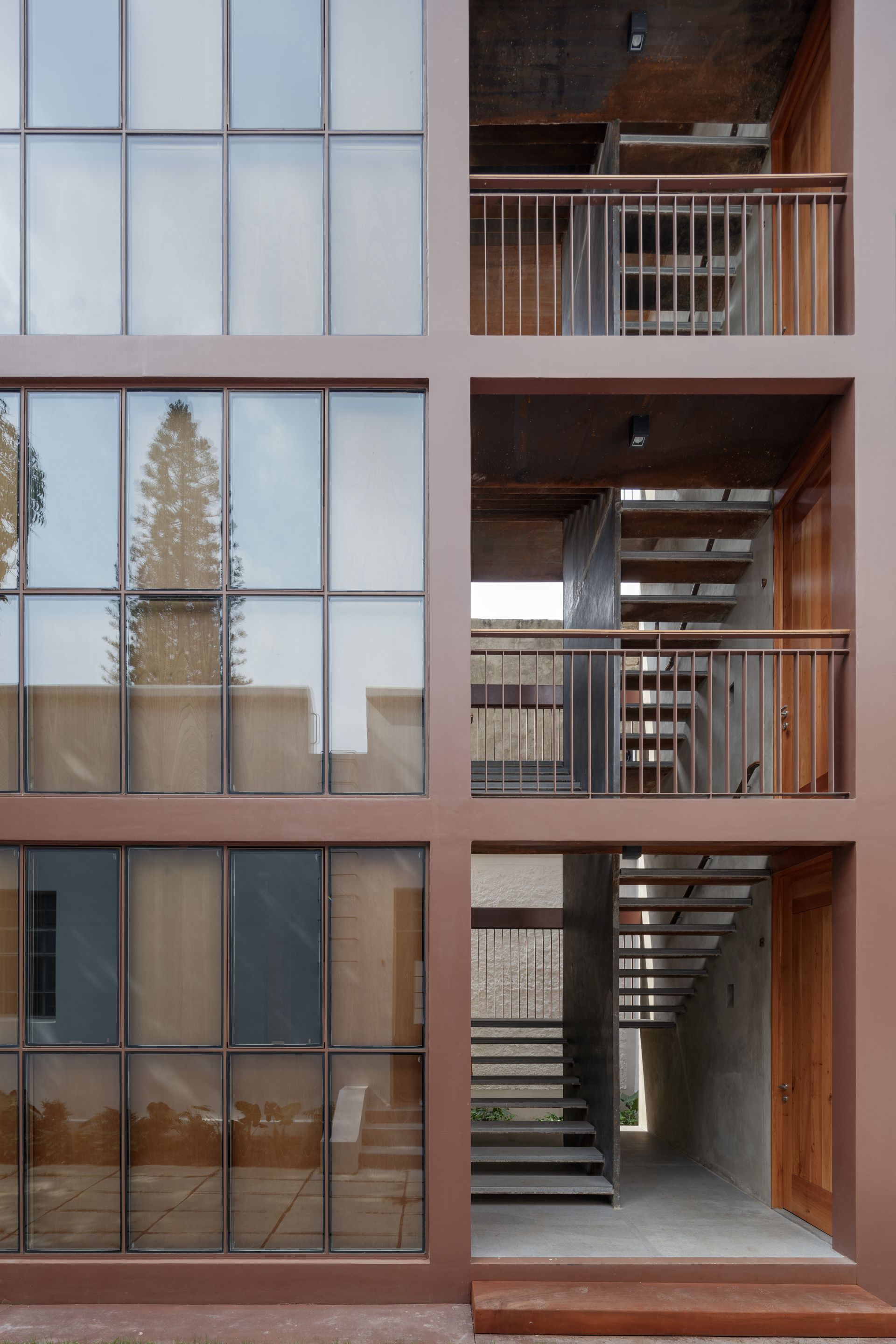 Brown building exterior with glass windows and open stairwells.