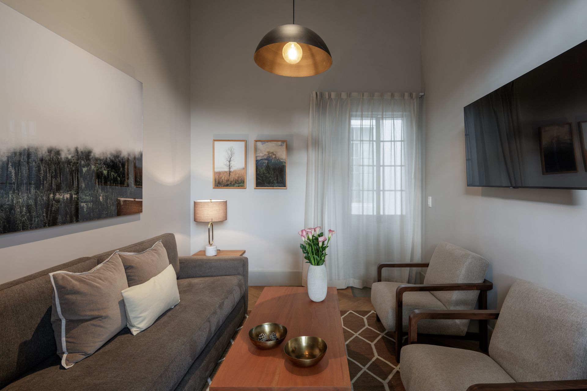 A living room with a couch , chairs and a coffee table.