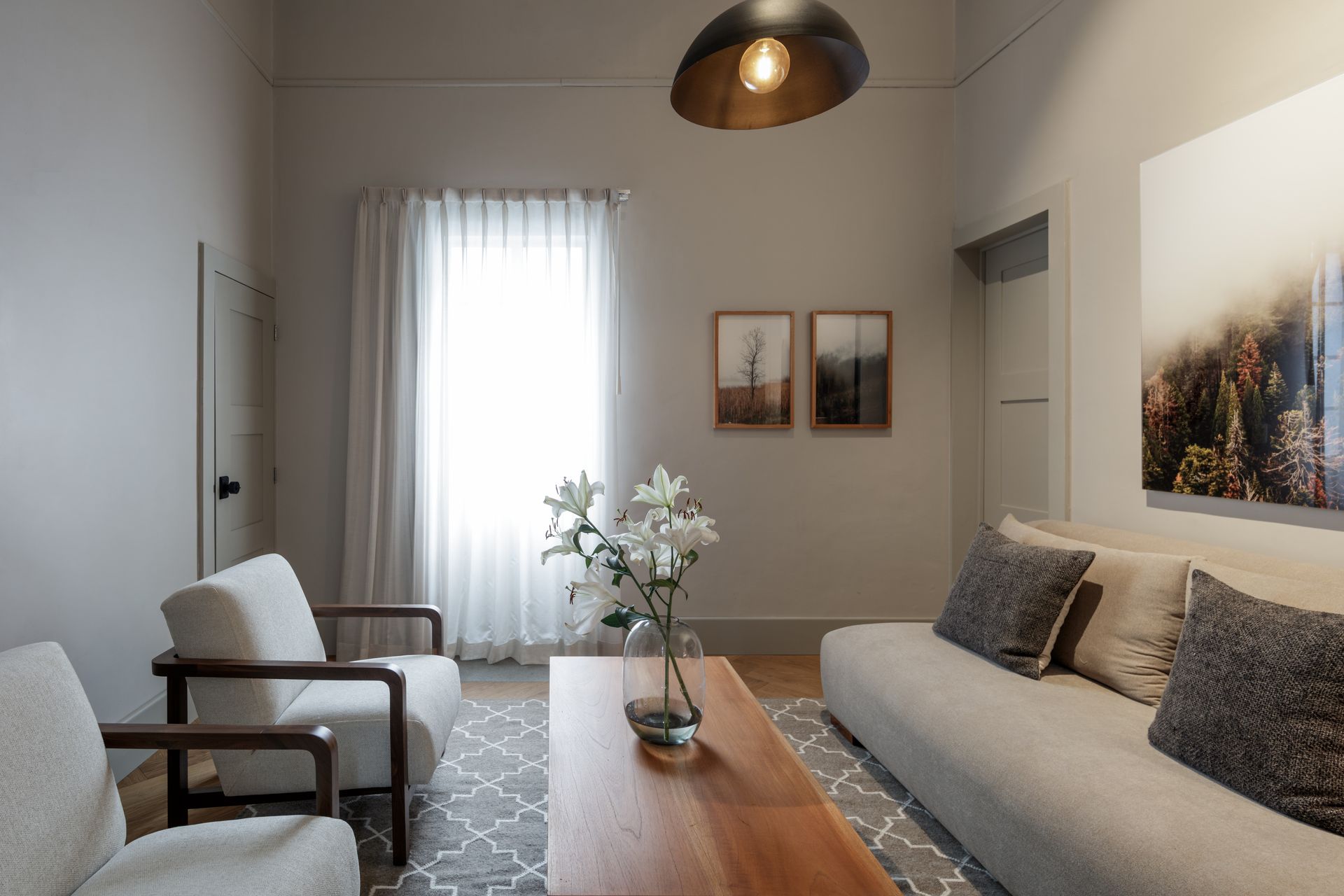 A living room with a couch , chairs , and a coffee table.
