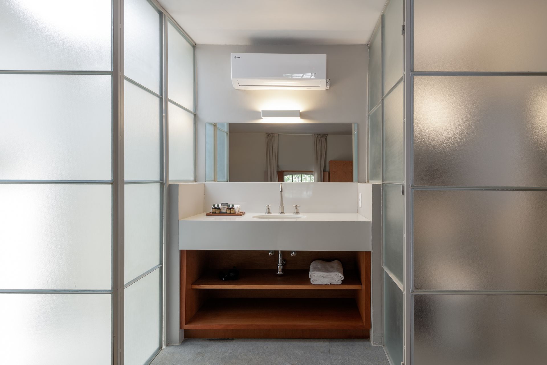 A bathroom with a sink , mirror and sliding glass doors.