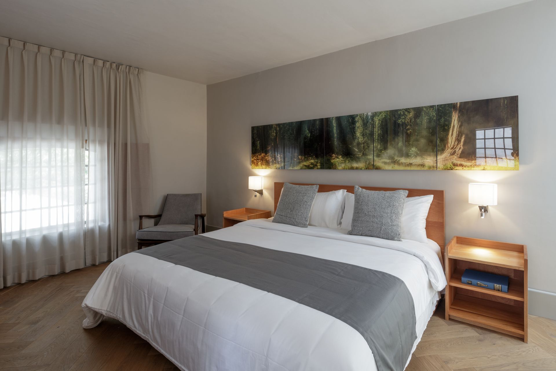 A hotel room with a king size bed and a chair.