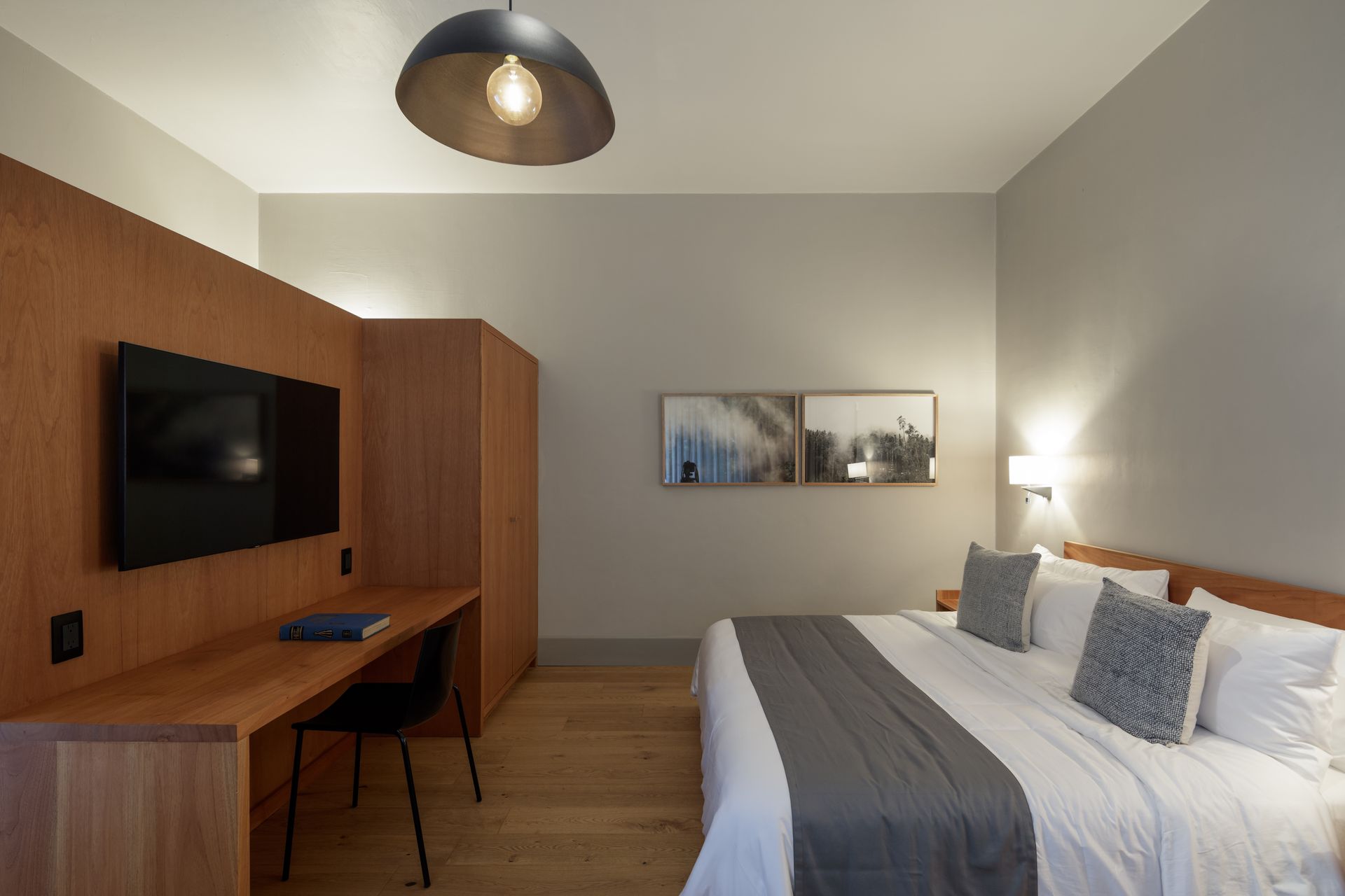 A hotel room with a king size bed and a flat screen tv