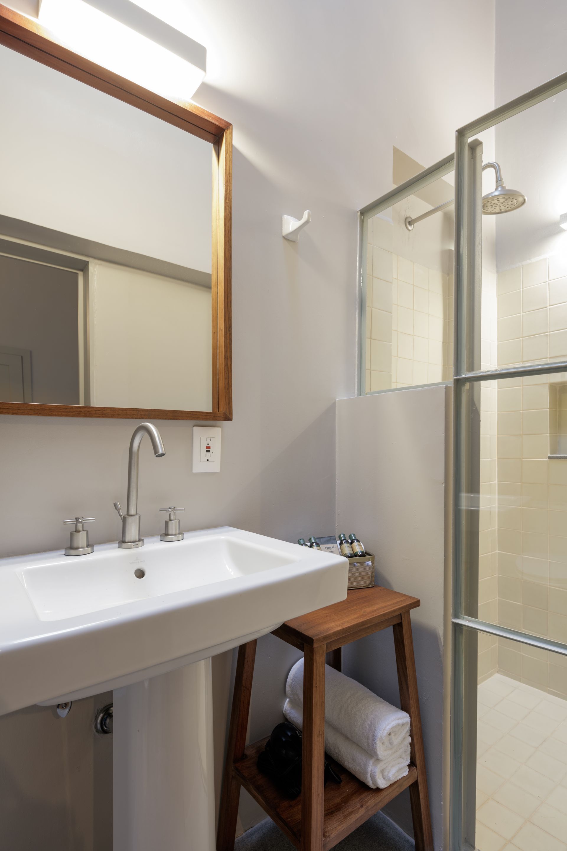 A bathroom with a sink , mirror and shower.
