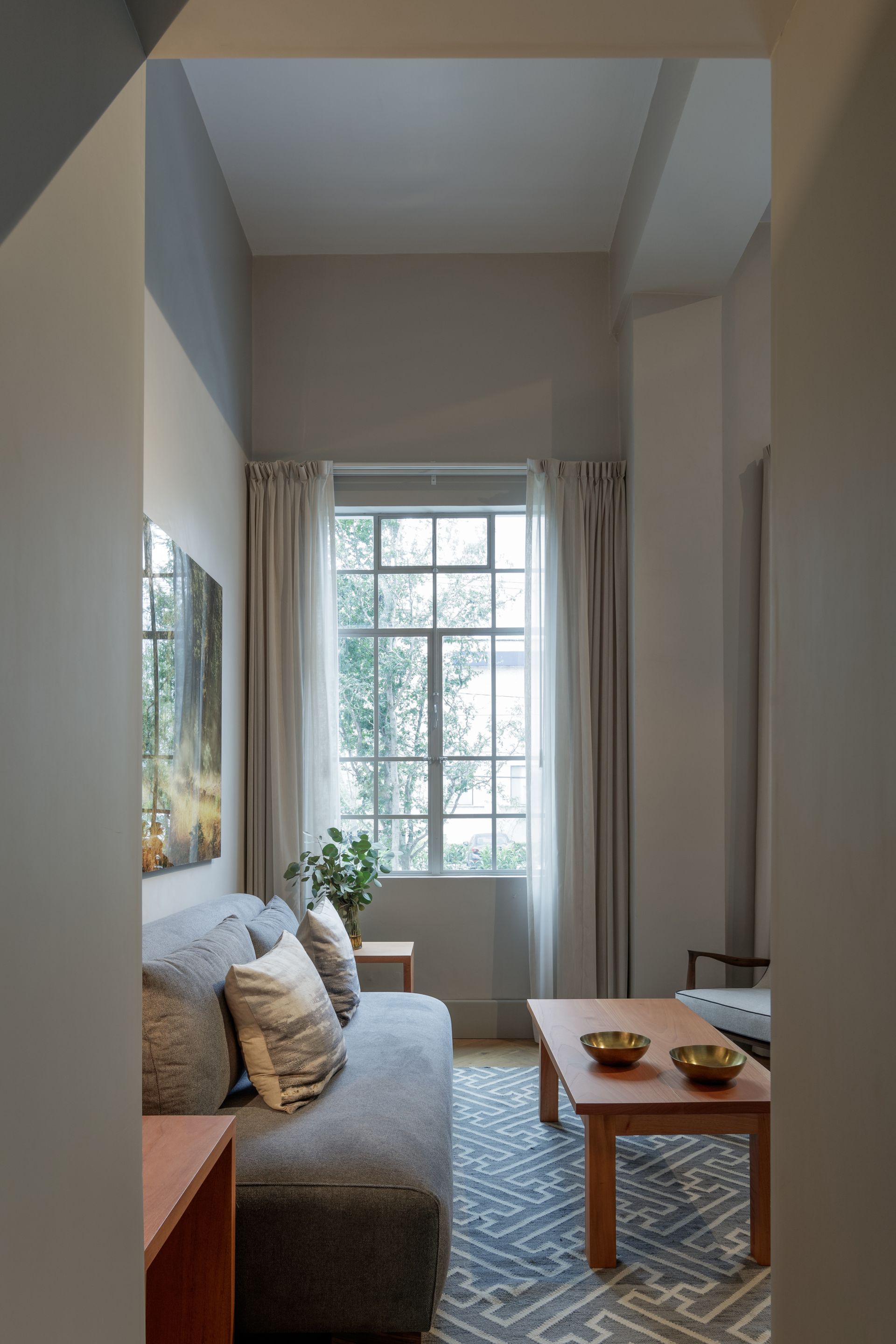 A living room with a couch , coffee table , and window.