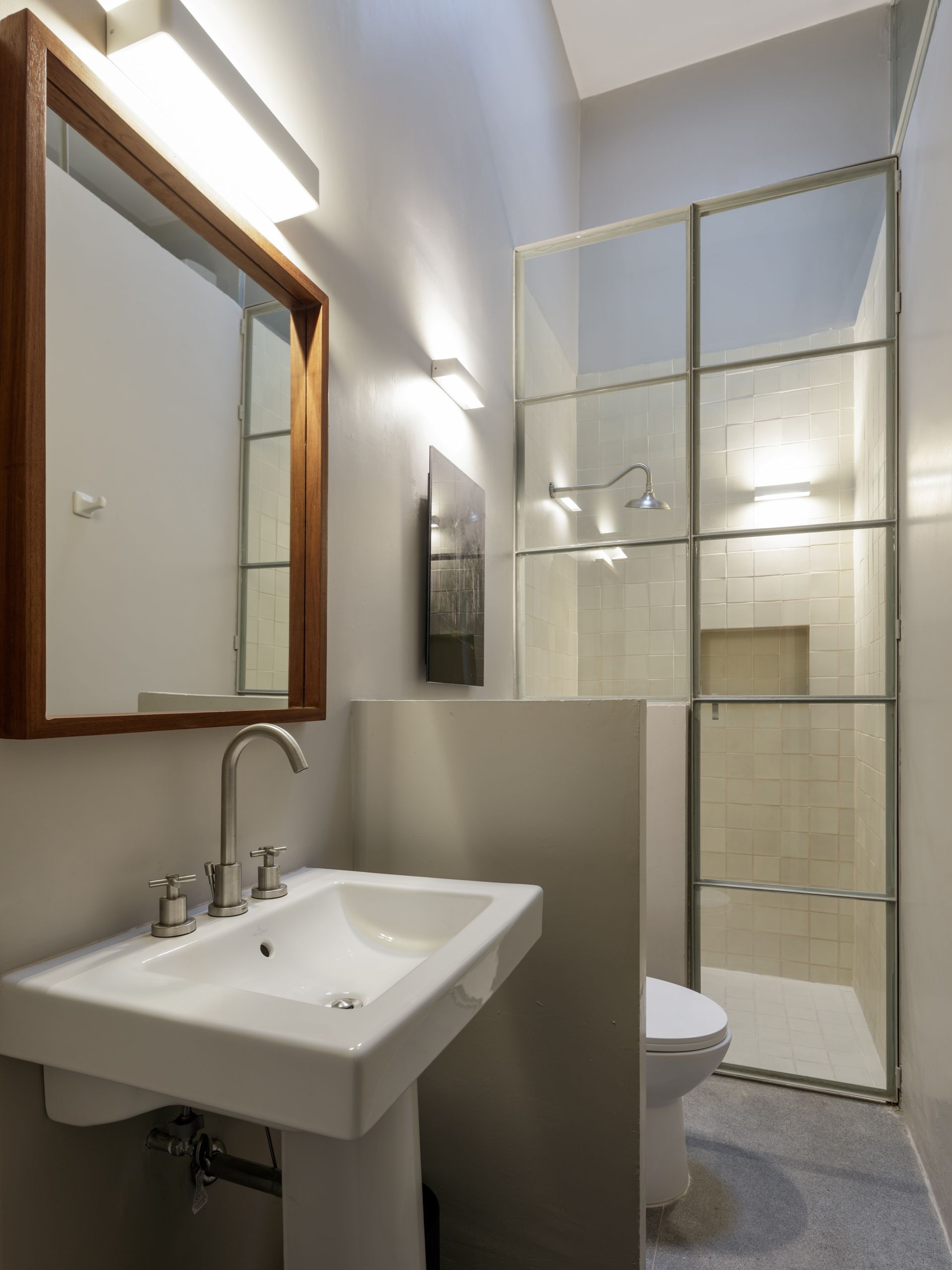 A bathroom with a sink toilet and mirror