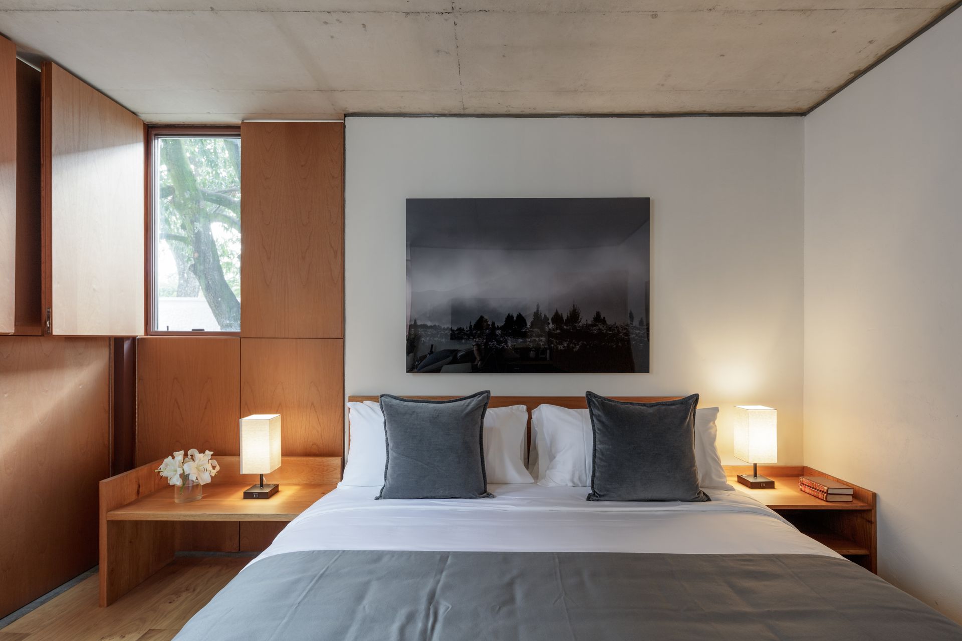 A bedroom with a bed and a painting on the wall