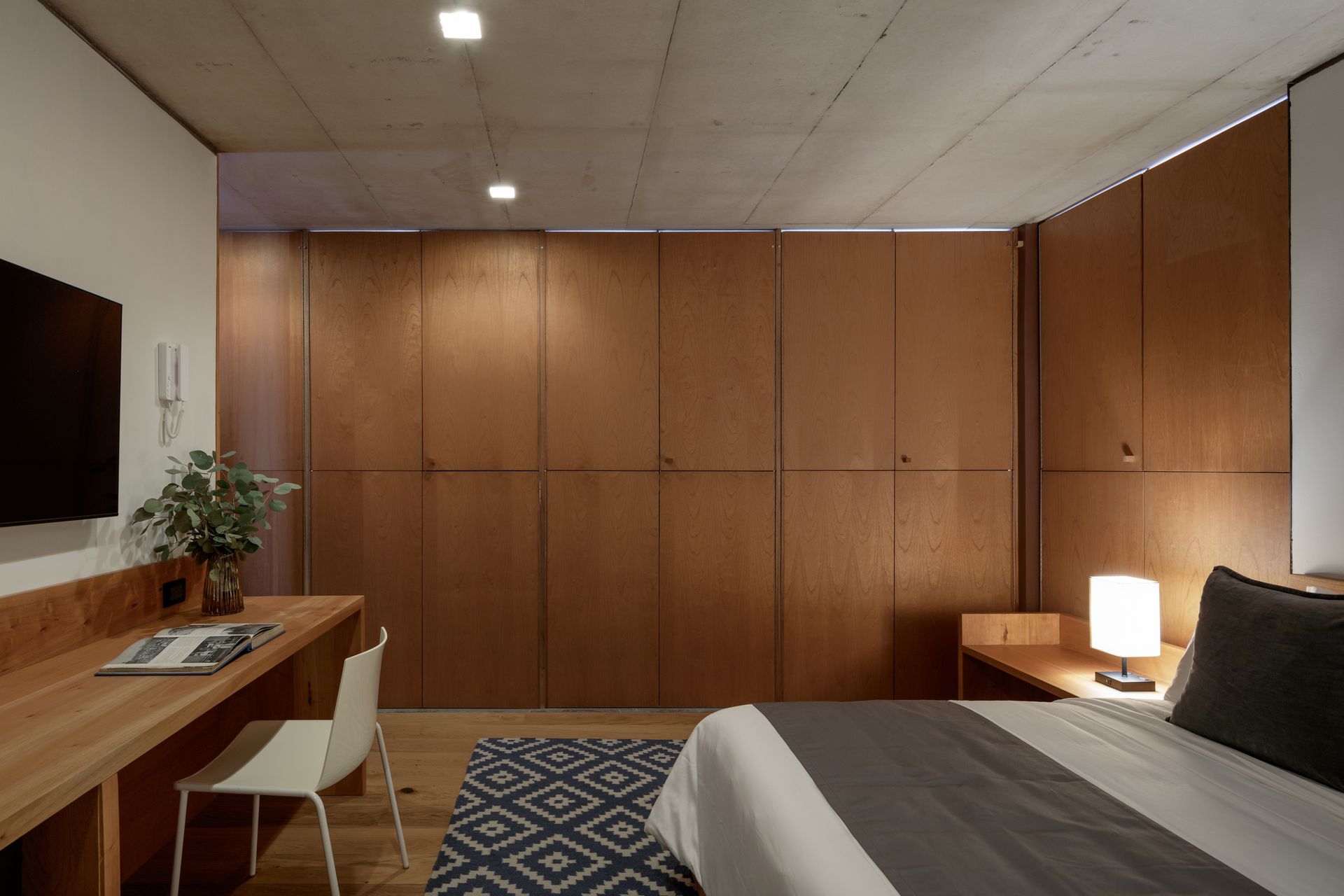 A bedroom with a bed , desk , chair and television