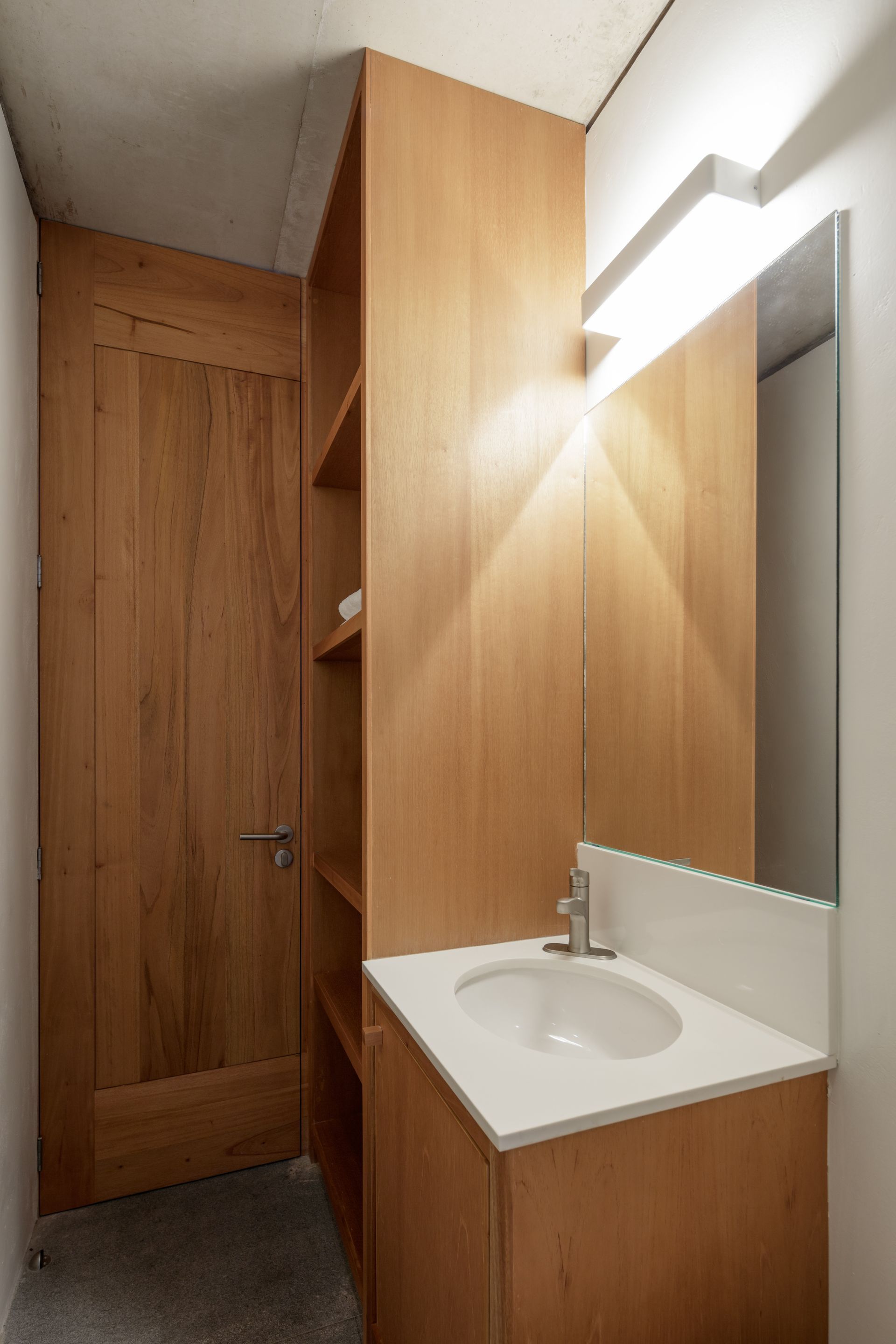A bathroom with a sink , mirror and wooden cabinets