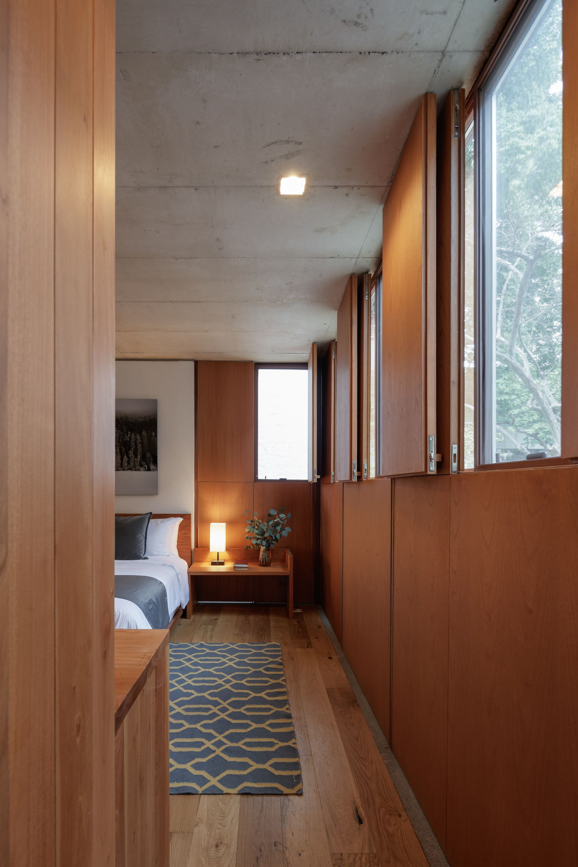 A bedroom with two beds and a rug on the floor