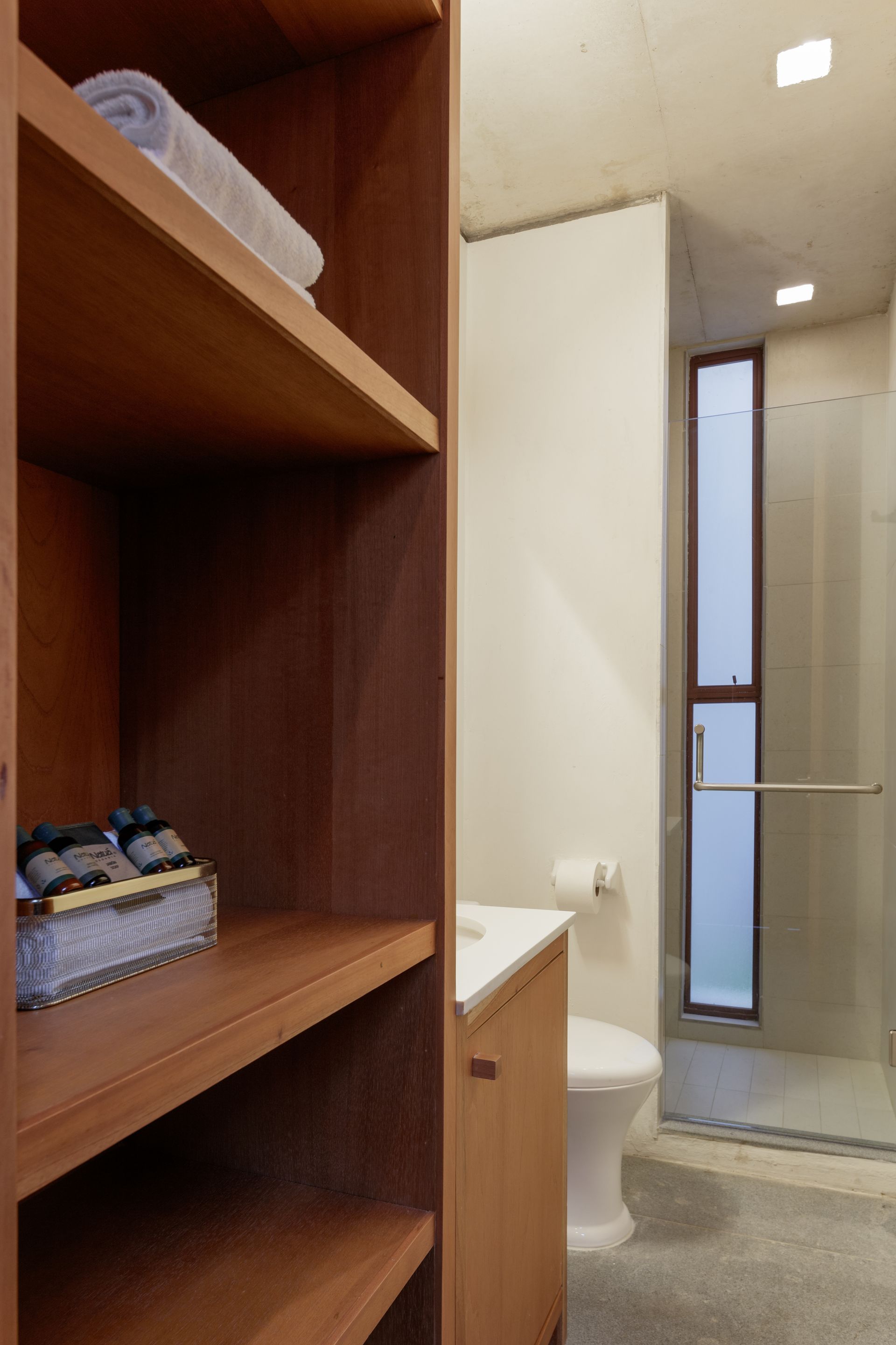 A bathroom with a toilet a sink and a window