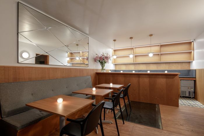 A restaurant with tables and chairs and a large mirror on the wall.