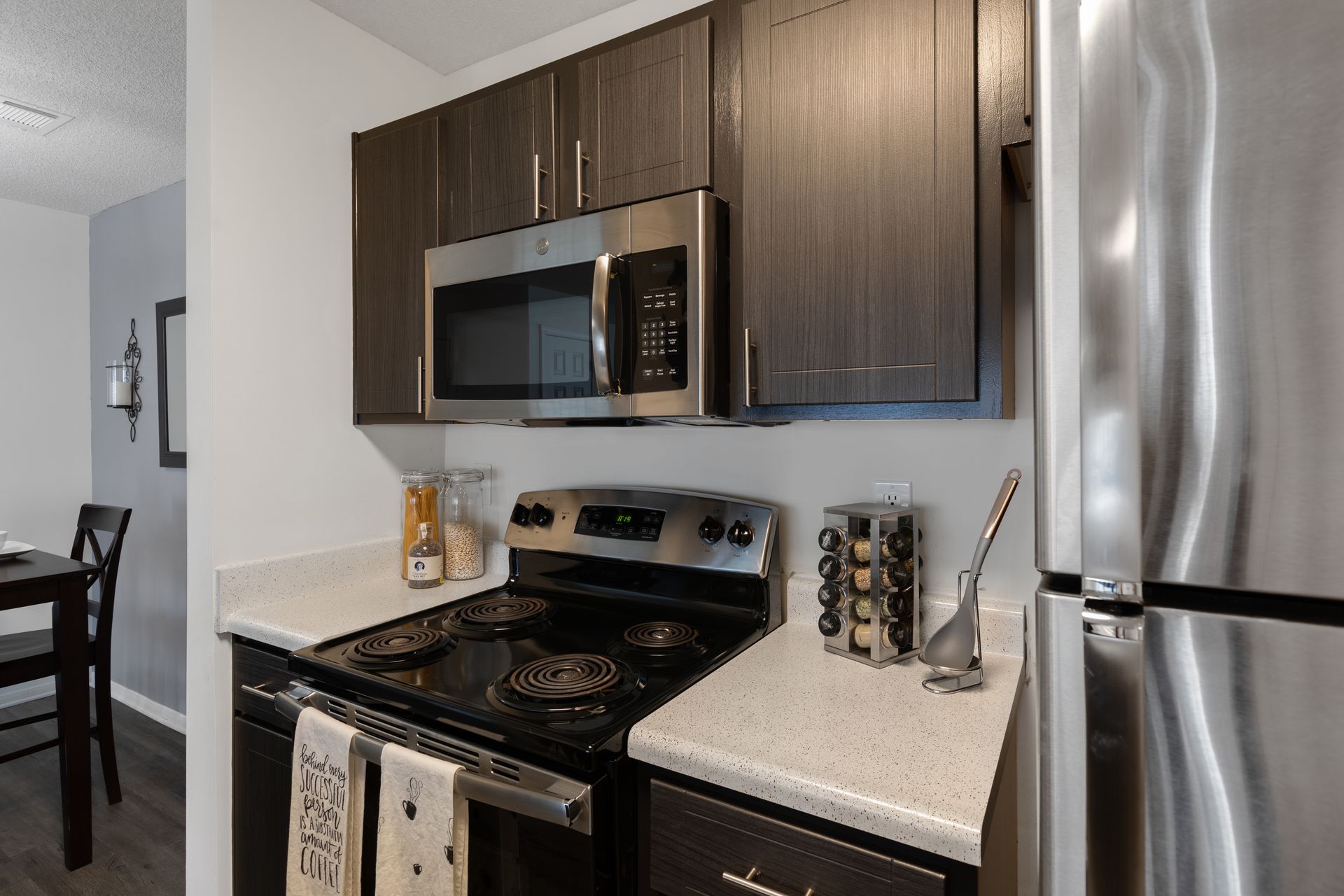 A kitchen with a stove , microwave , and refrigerator.