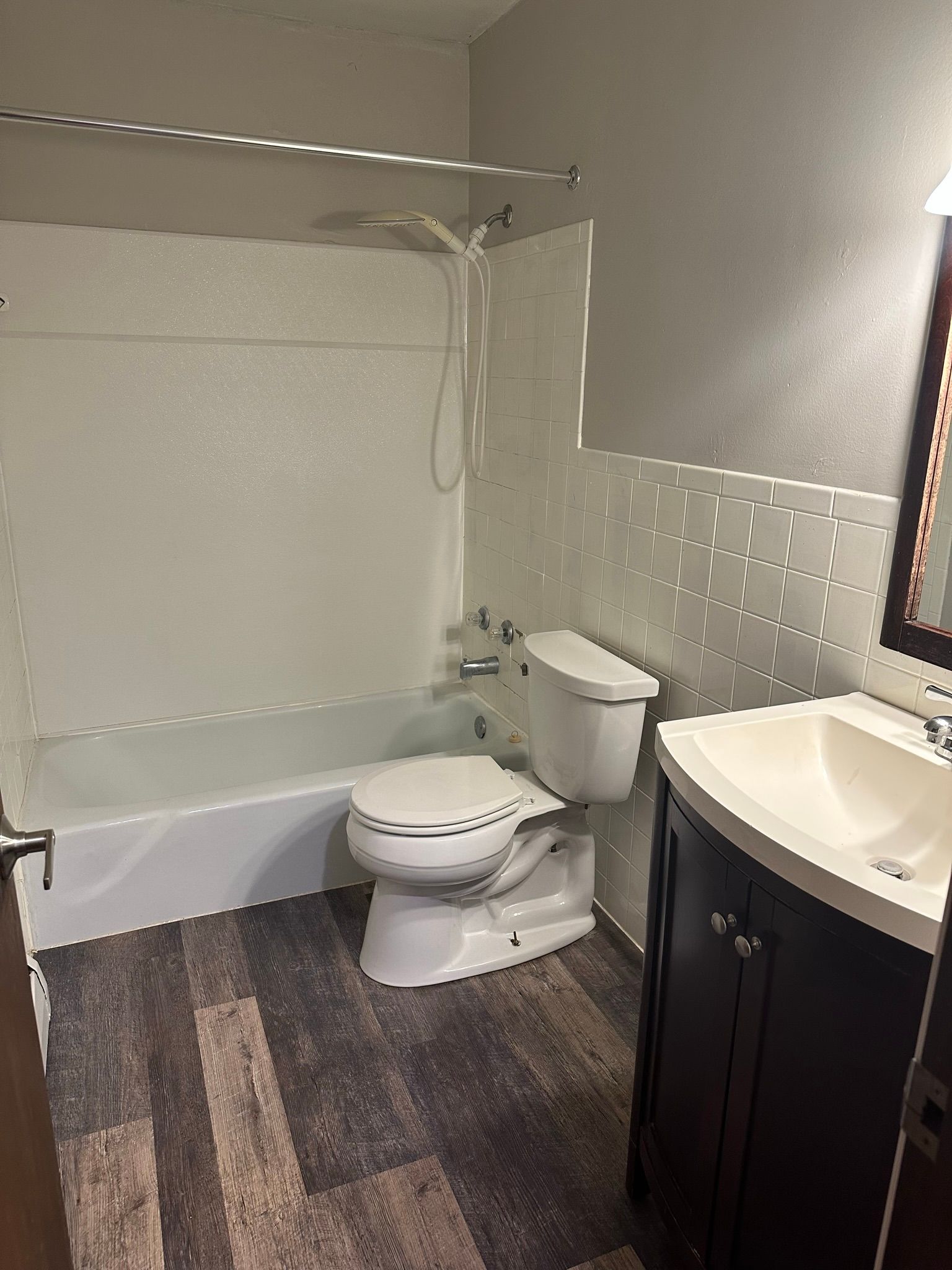 A bathroom with a toilet , sink , and bathtub.