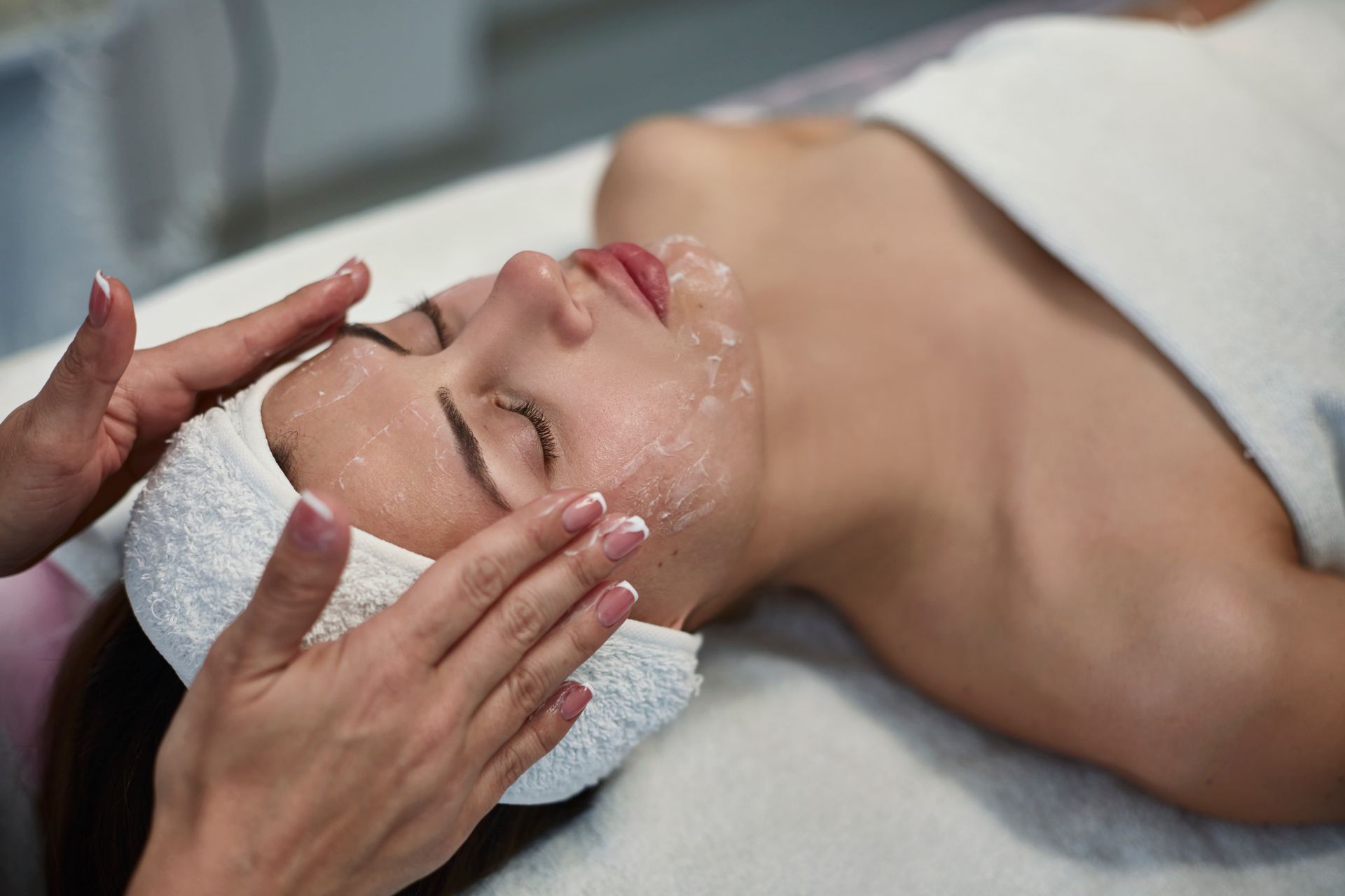 Una donna si sta sottoponendo a un trattamento viso in una spa.