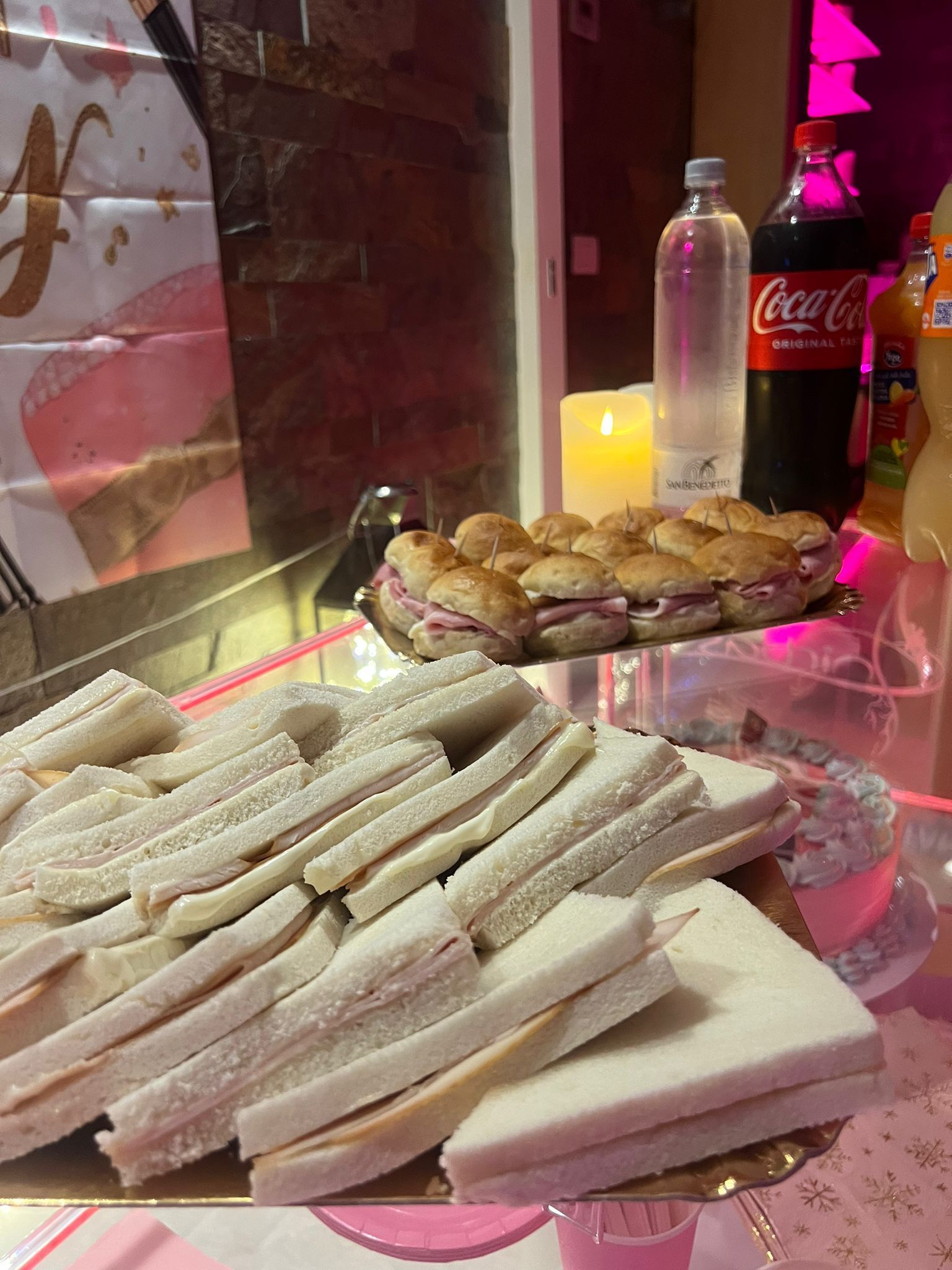 Un vassoio di panini e una bottiglia di coca cola su un tavolo.