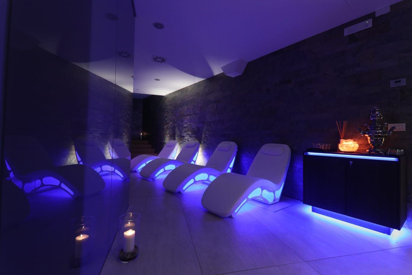 Una fila di sedie a sdraio in una stanza buia con luci blu.