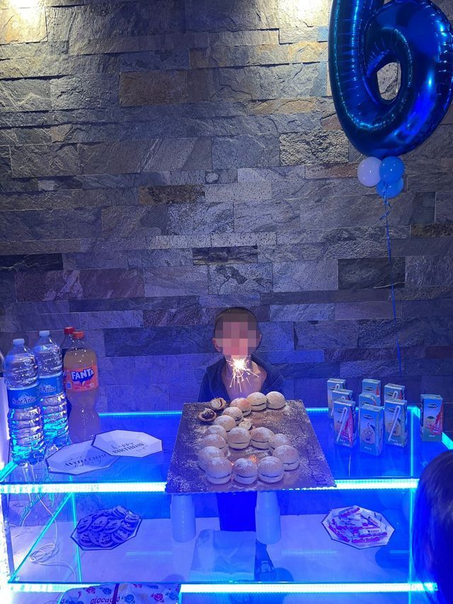 Un ragazzino soffia sulla candelina di una torta durante una festa di compleanno.