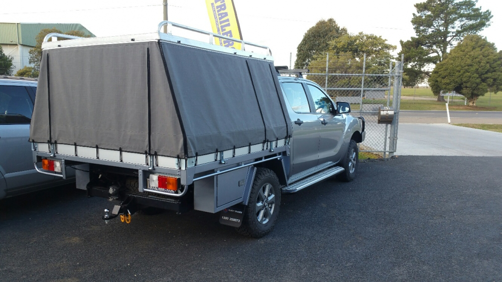A truck with a canopy on top of it is parked in a parking lot.