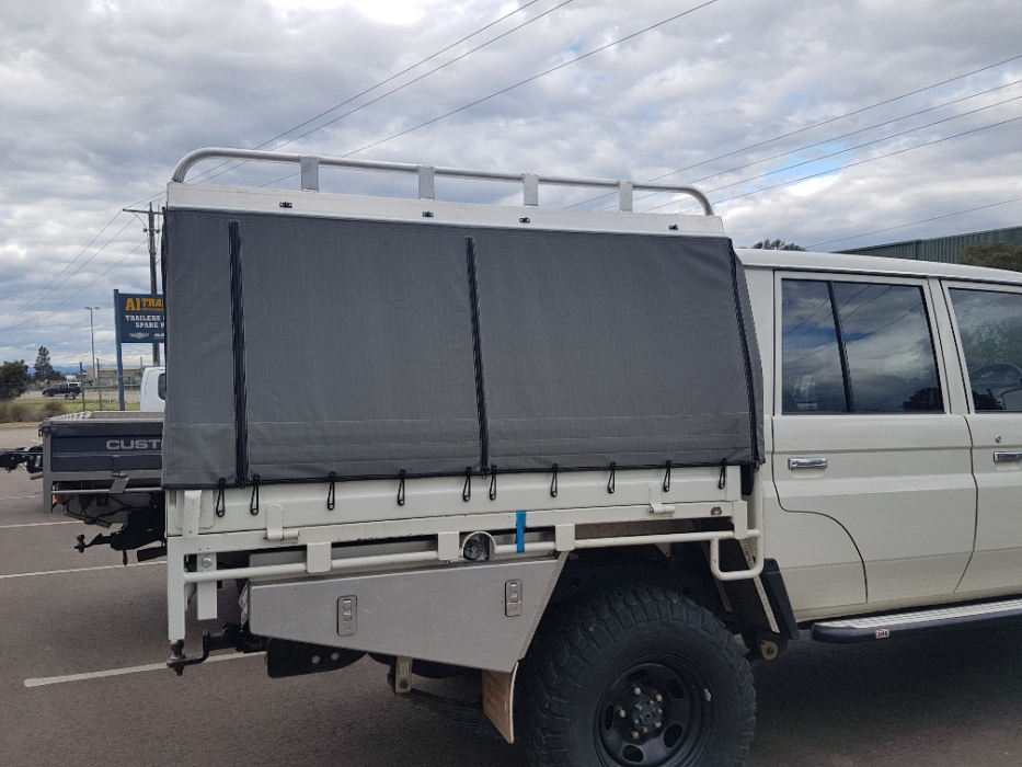 A white truck with a canopy on top of it is parked in a parking lot.