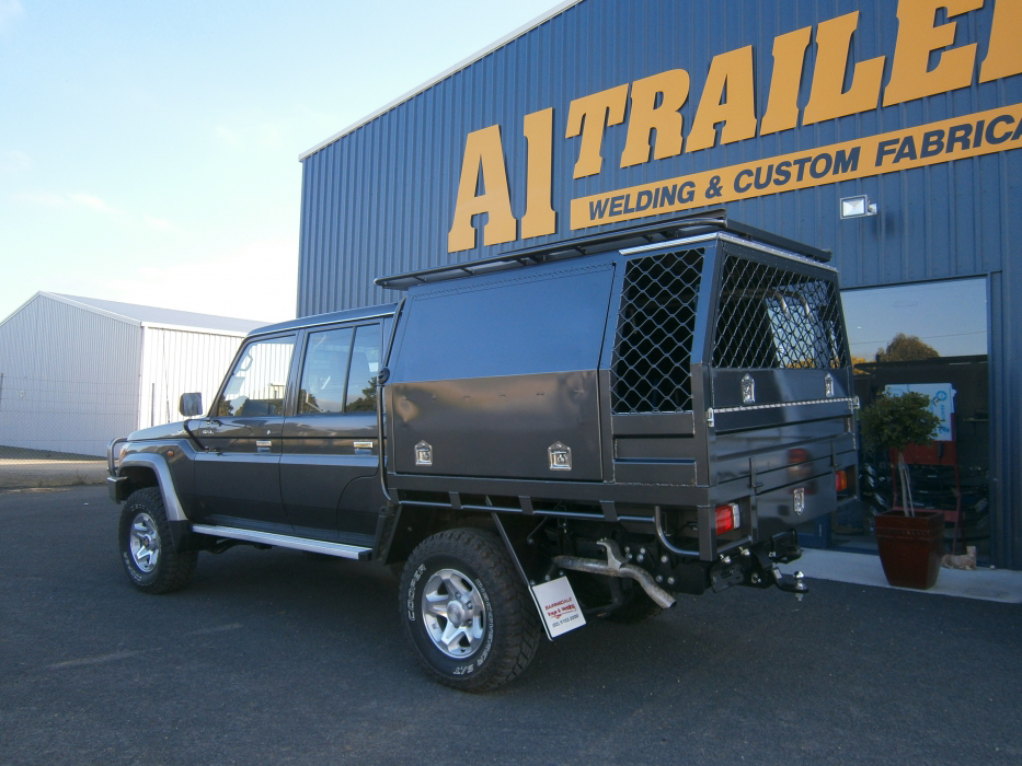 A black truck is parked in front of a welding and custom fabrication company