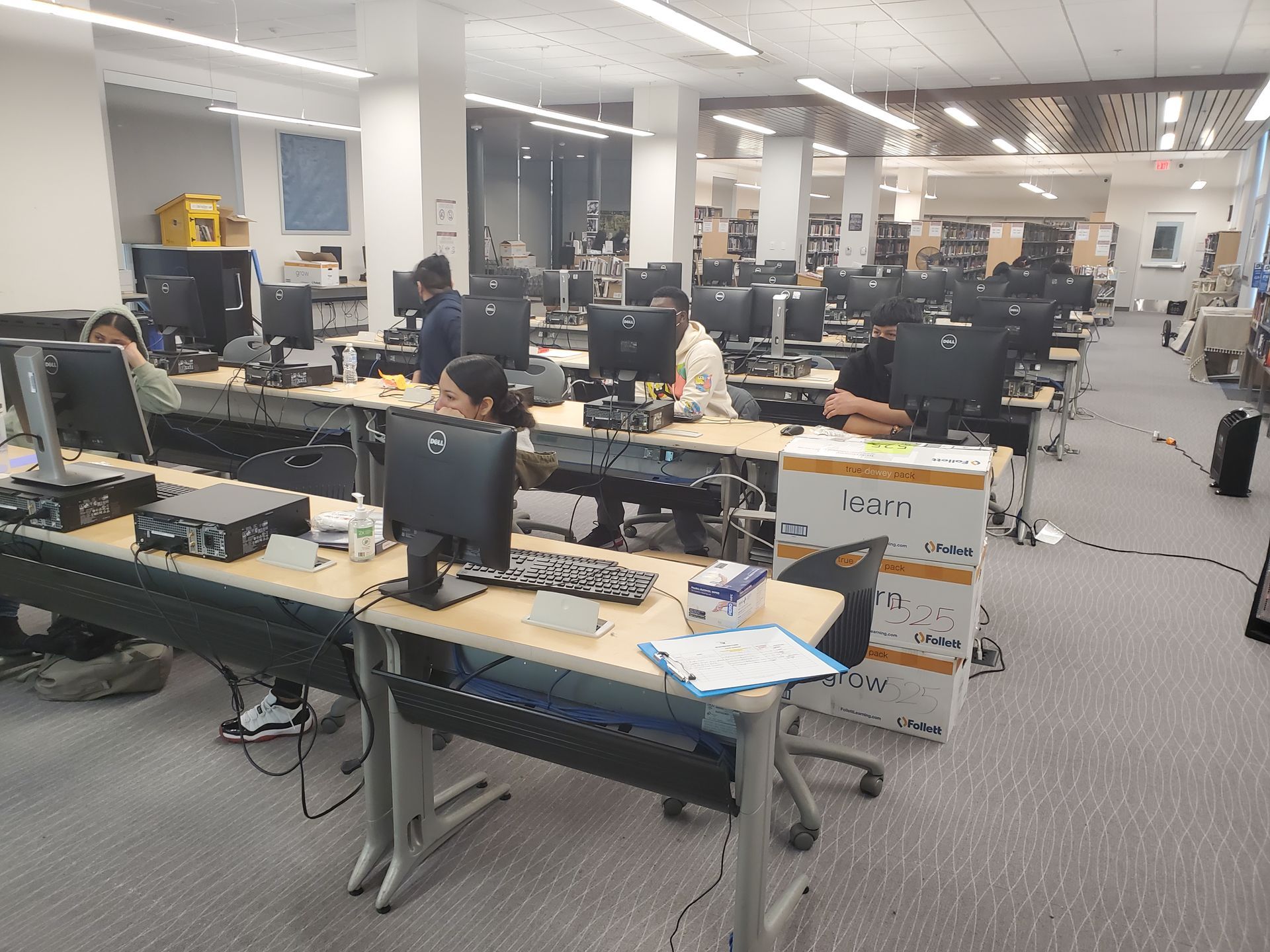 A group of people are working on computers in a large room.