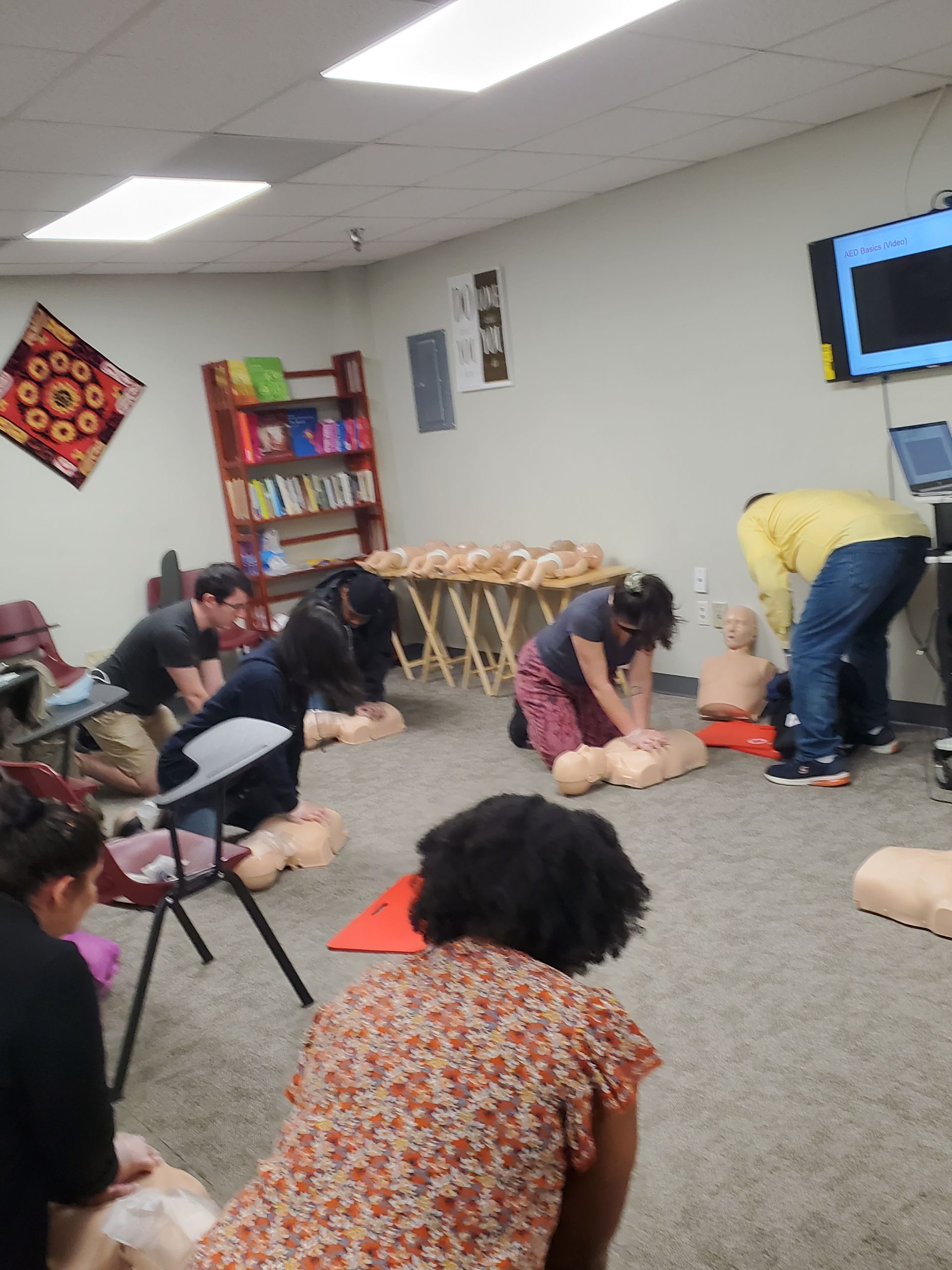 A group of people are practicing cpr on a mannequin