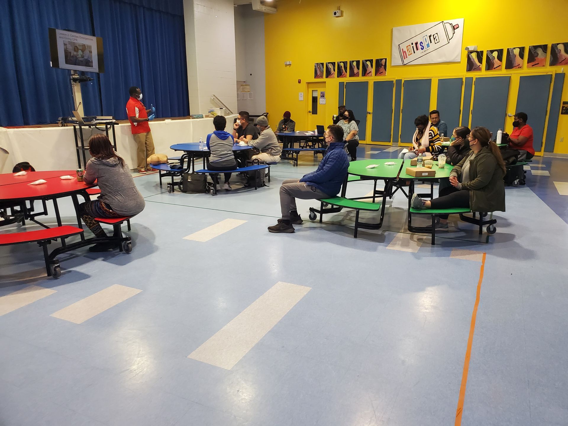 A group of people are sitting at tables in a school cafeteria