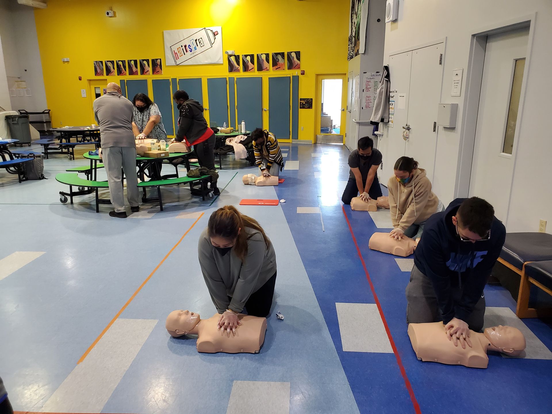 A group of people are practicing first aid on a mannequin.