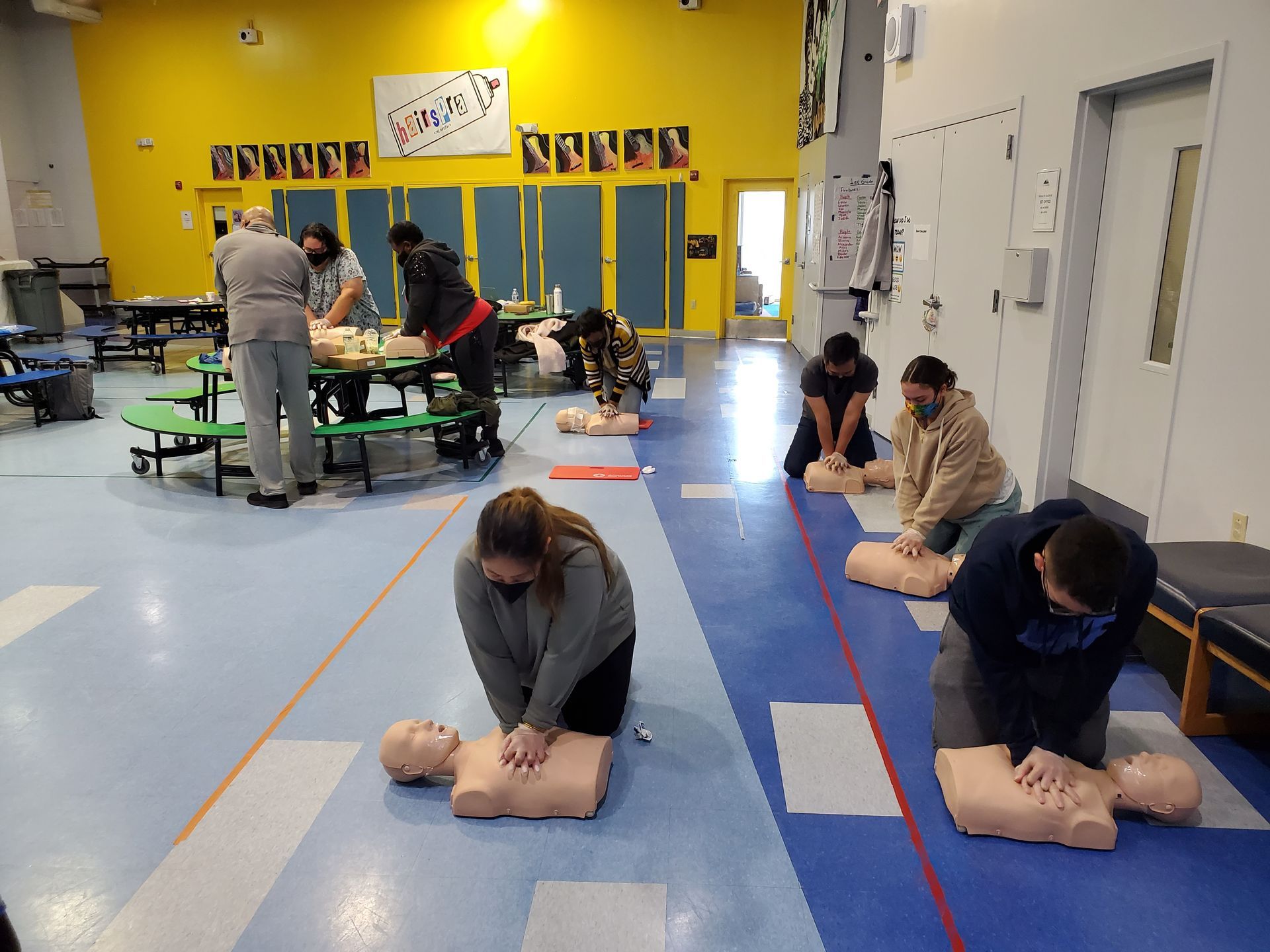 A group of people are practicing first aid on a mannequin.