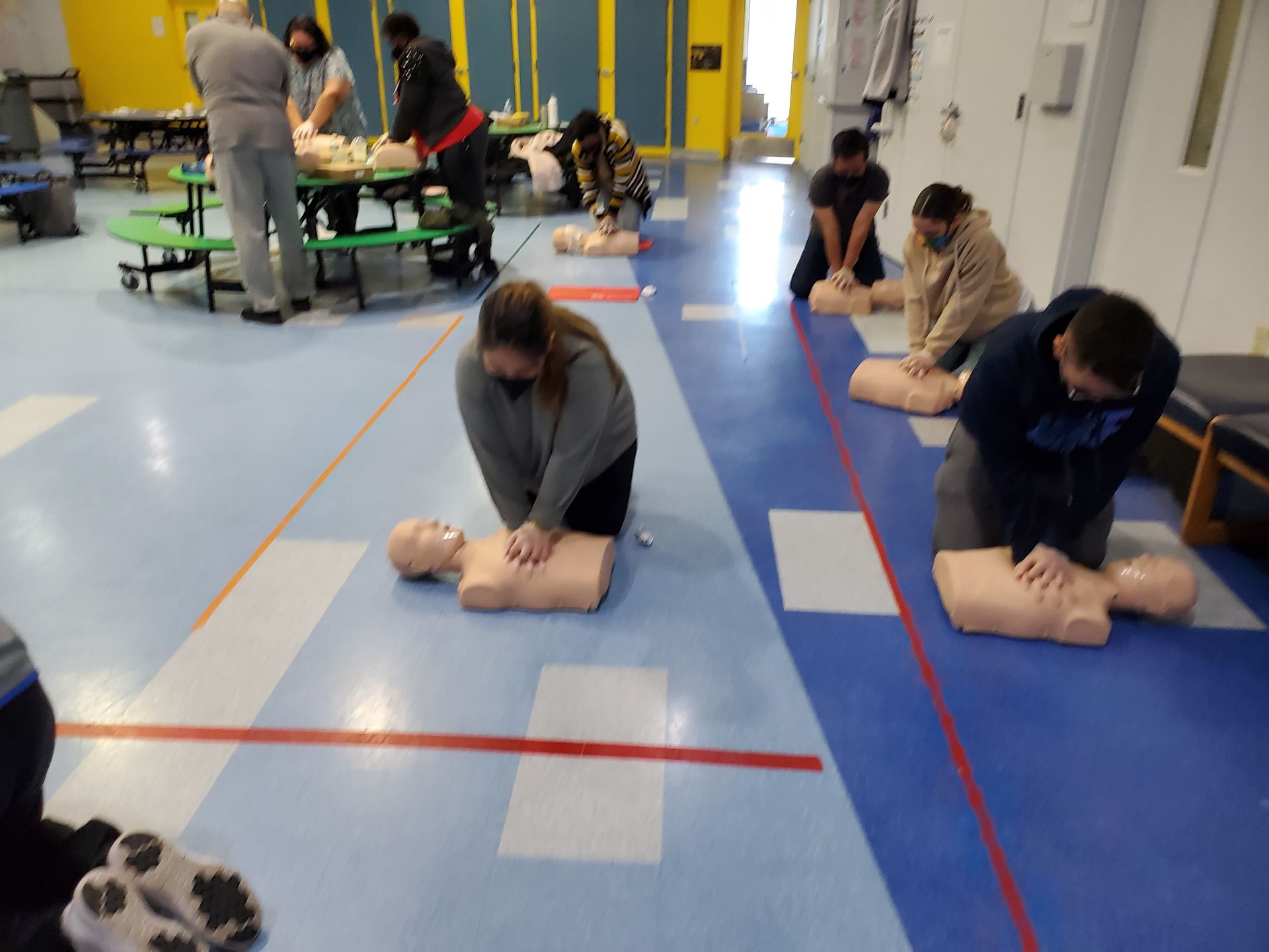 A group of people are practicing first aid on a mannequin