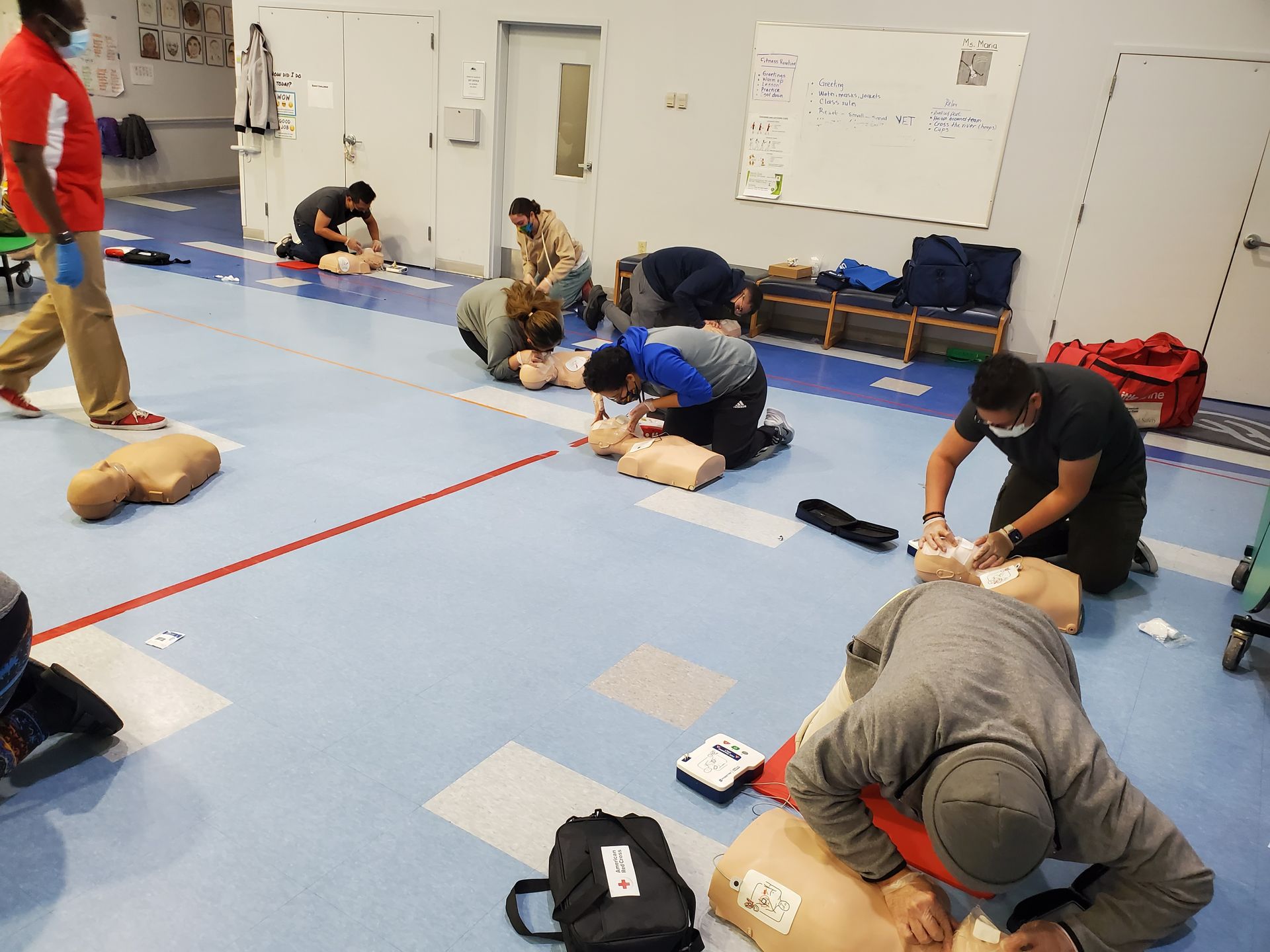 A group of people are practicing first aid on a mannequin.