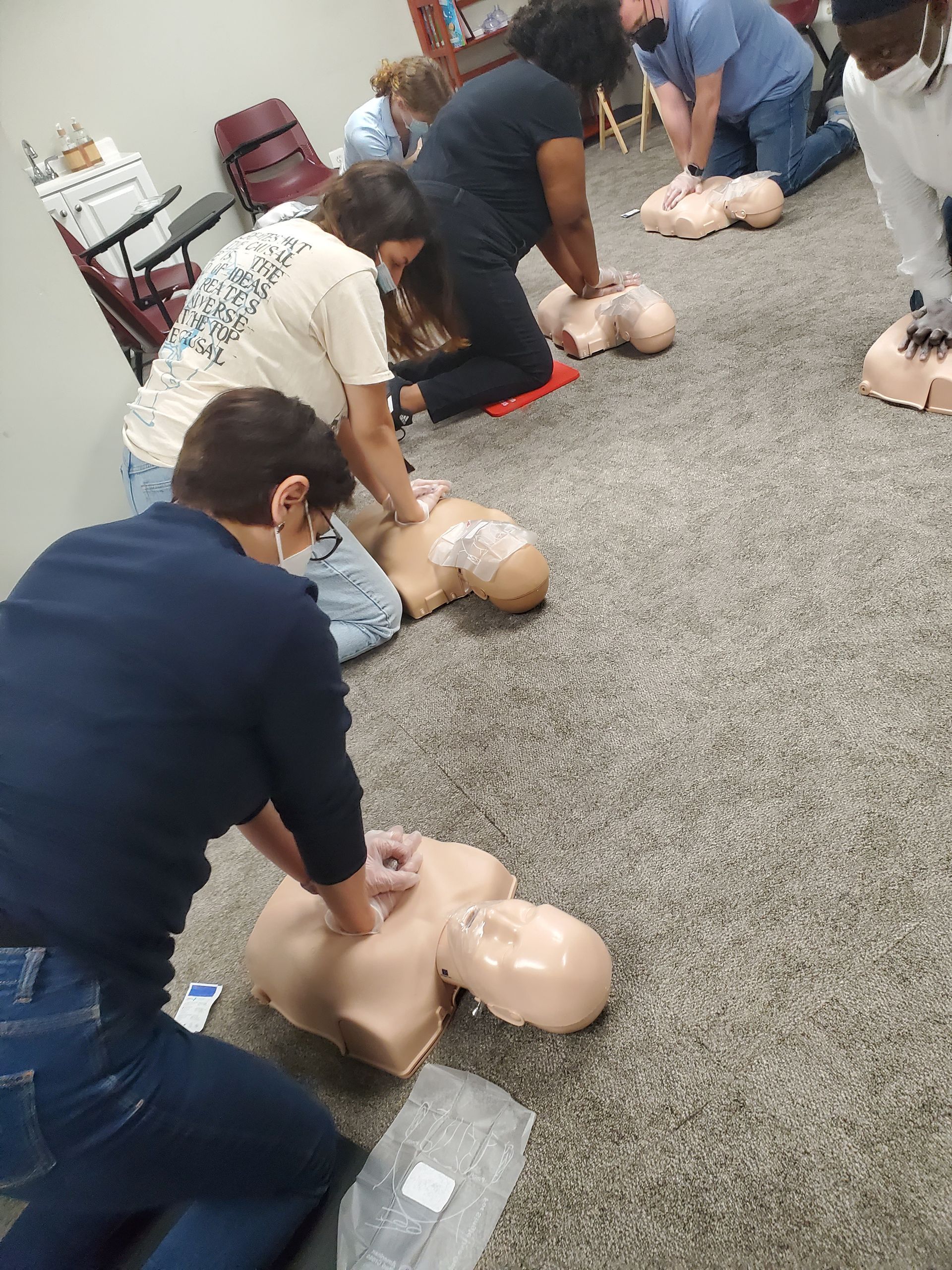 A group of people are practicing cpr on a mannequin.