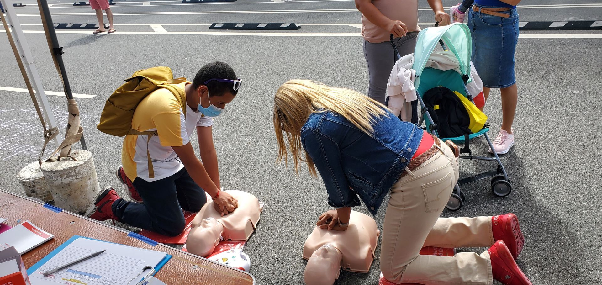 A group of people are practicing a first aid on a mannequin.