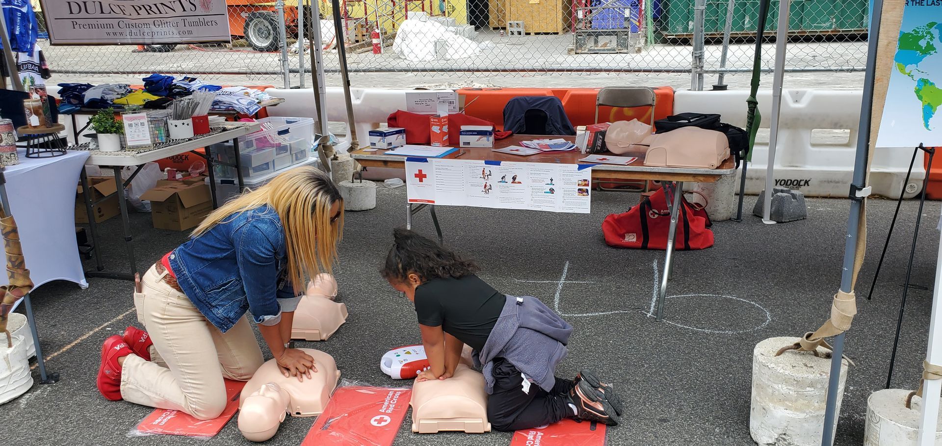 Two women are practicing first aid on a mannequin.