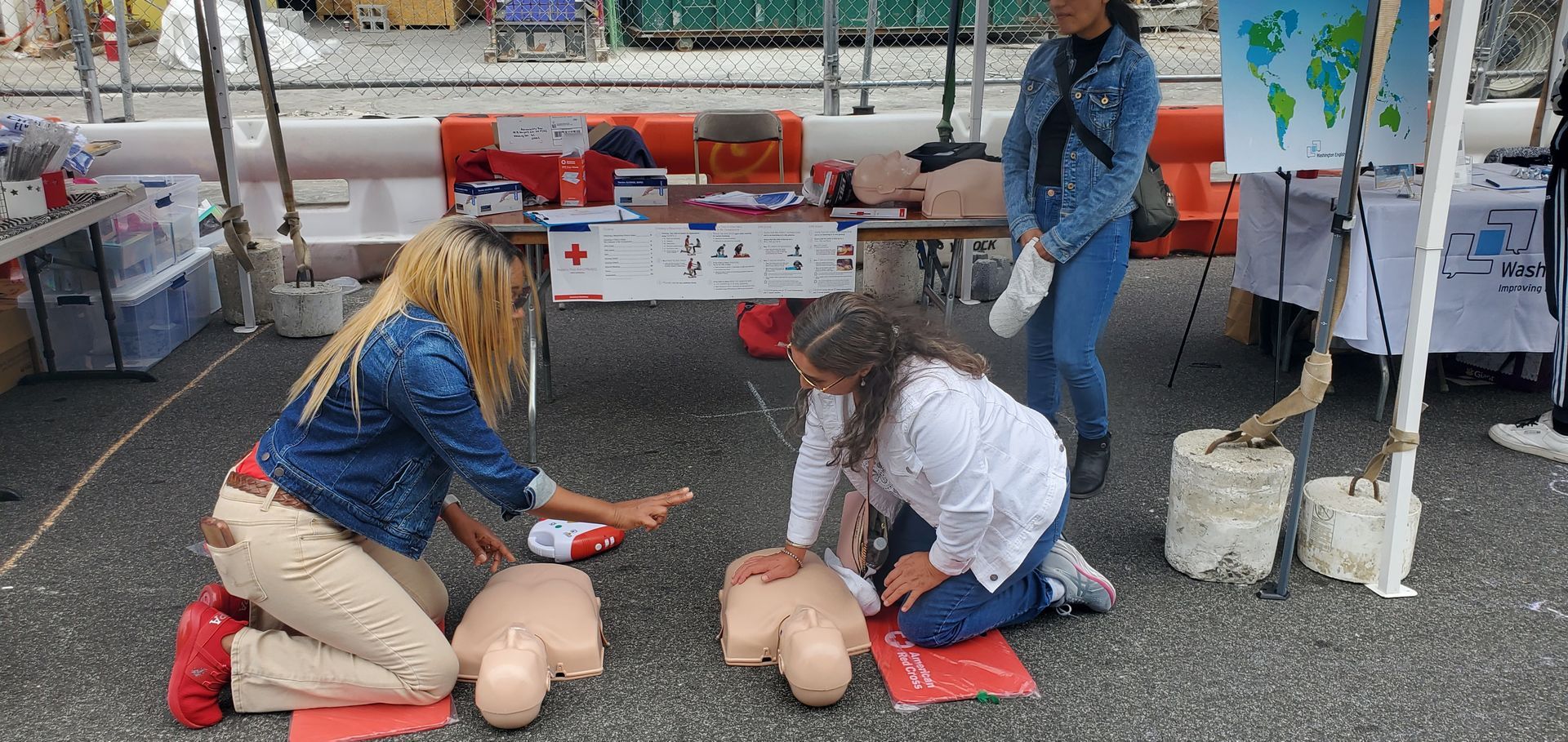 A group of people are practicing first aid on a mannequin.