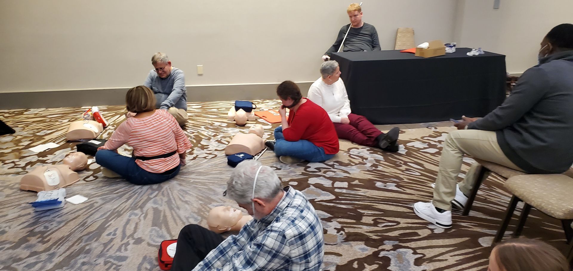 A group of people are sitting on the floor in a room.