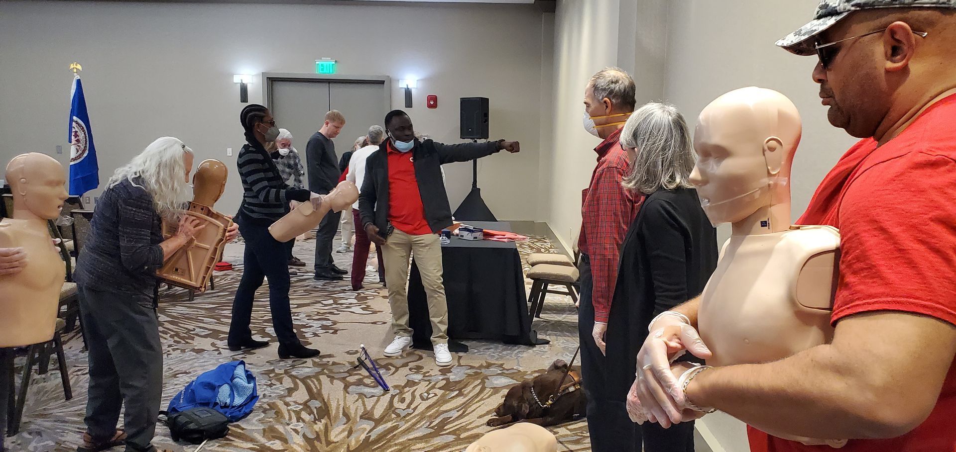 A group of people are standing around a mannequin in a room.