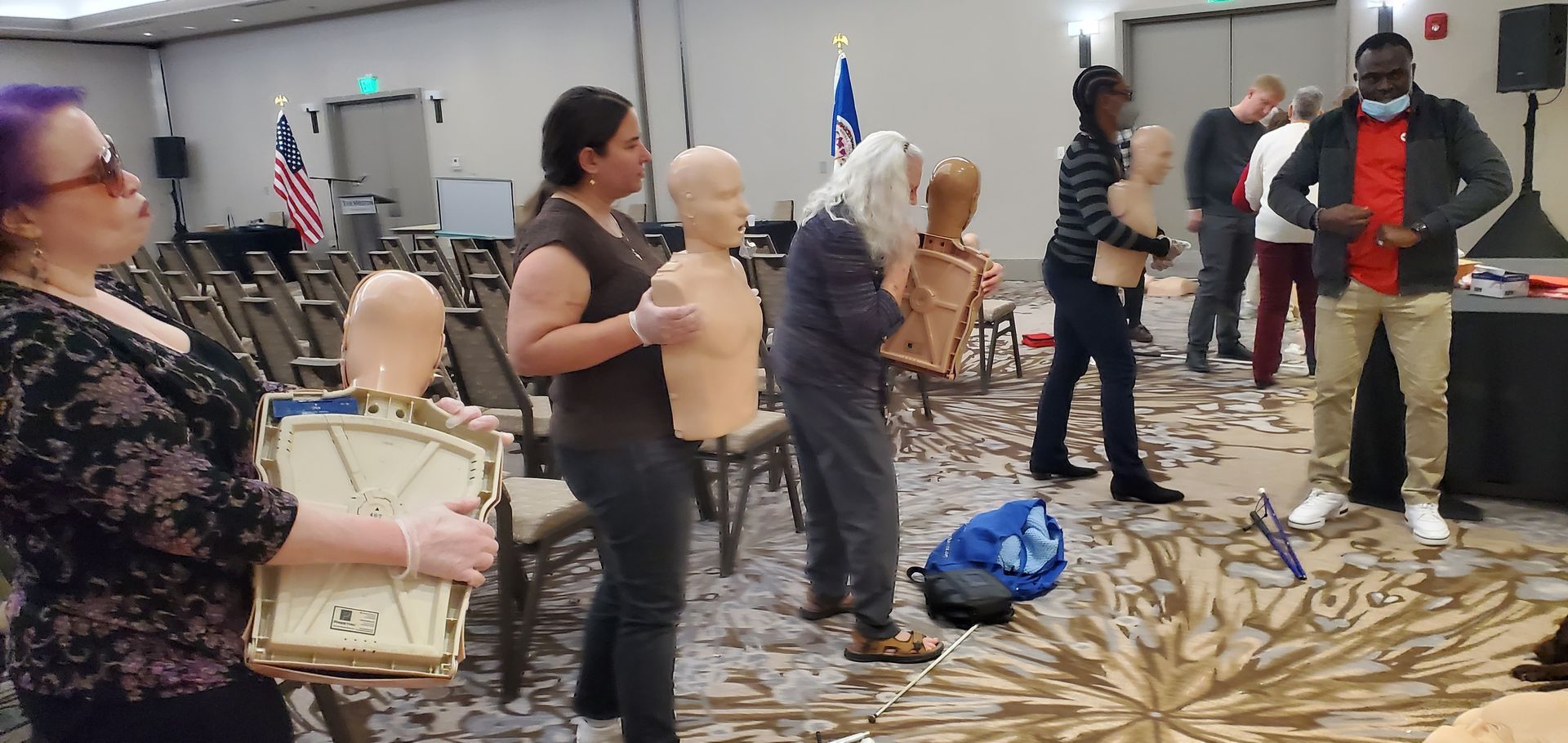 A group of people are standing in a room holding mannequins.