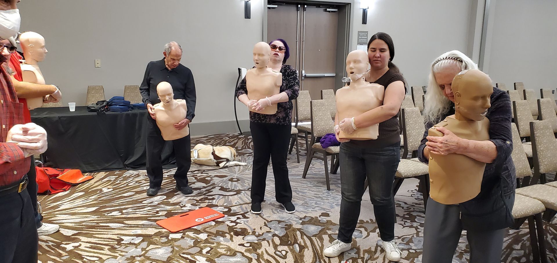 A group of people are standing around mannequins in a room.