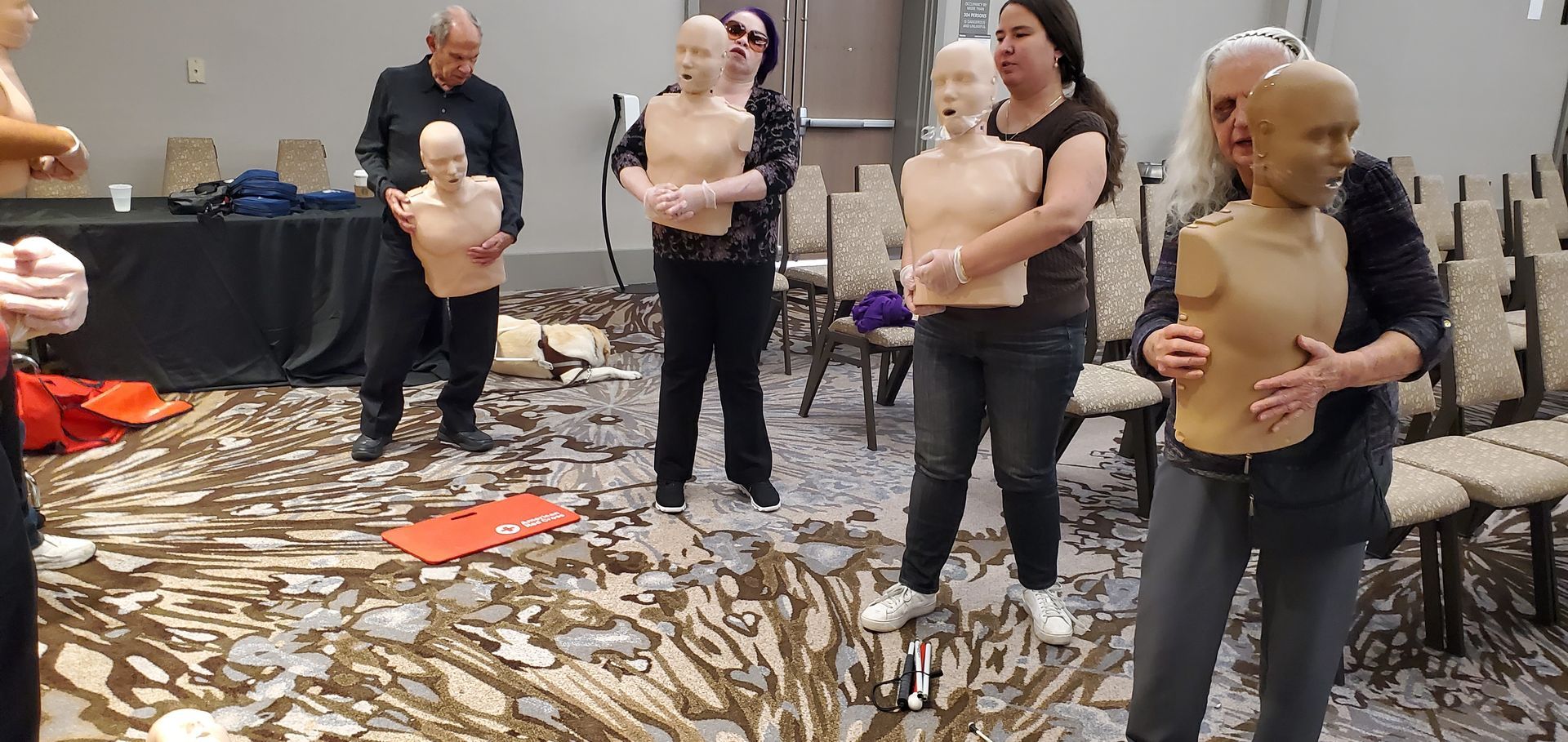 A group of people are standing around mannequins in a room.