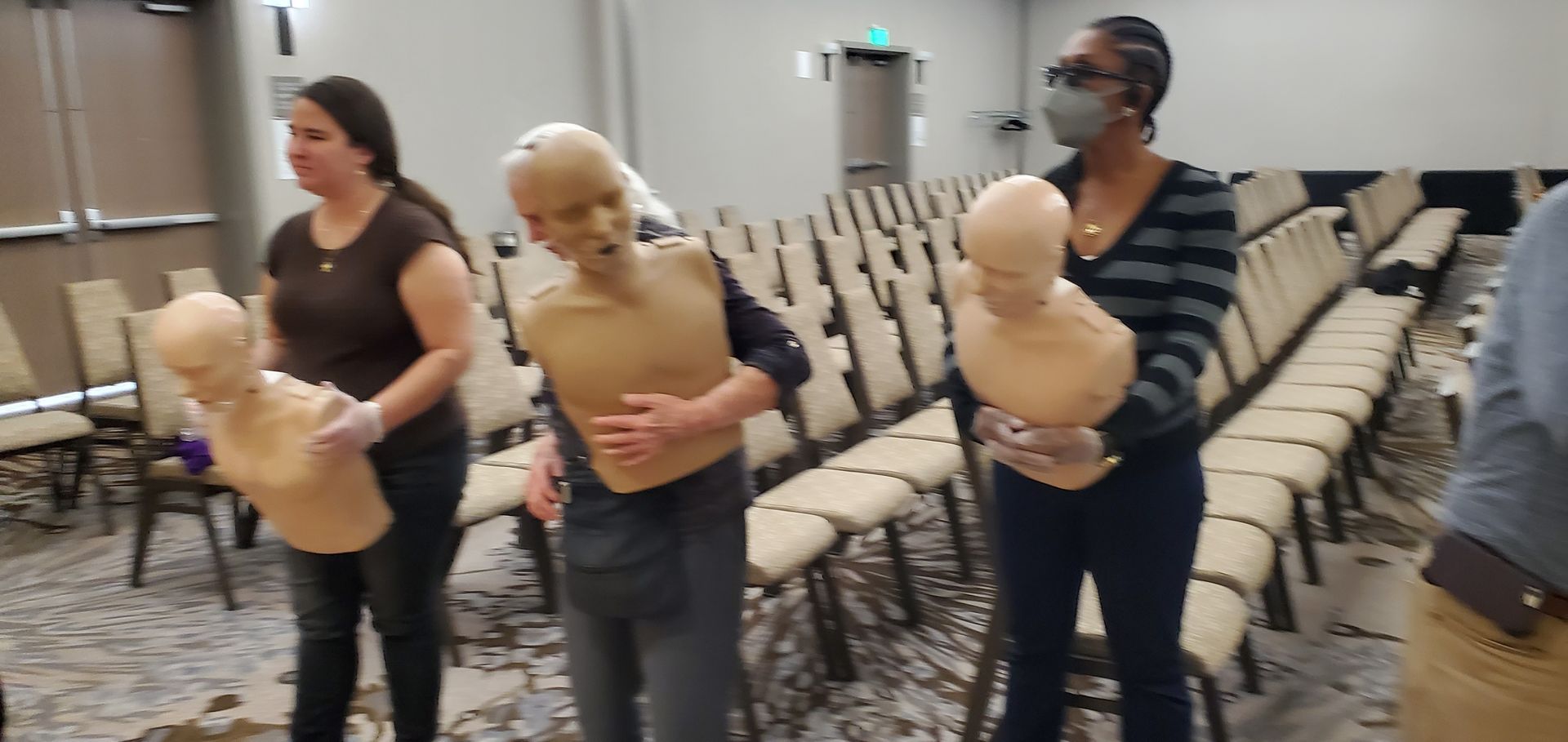 A group of people are holding mannequins in a room.