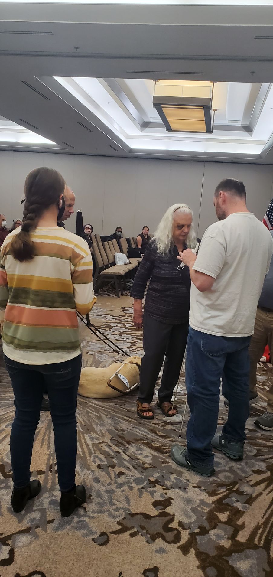 A group of people are standing in a room talking to each other.