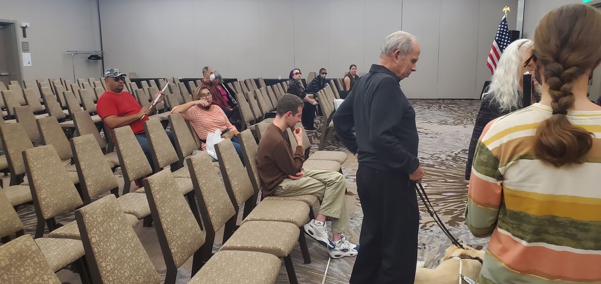 A group of people are sitting in rows of chairs in a room.